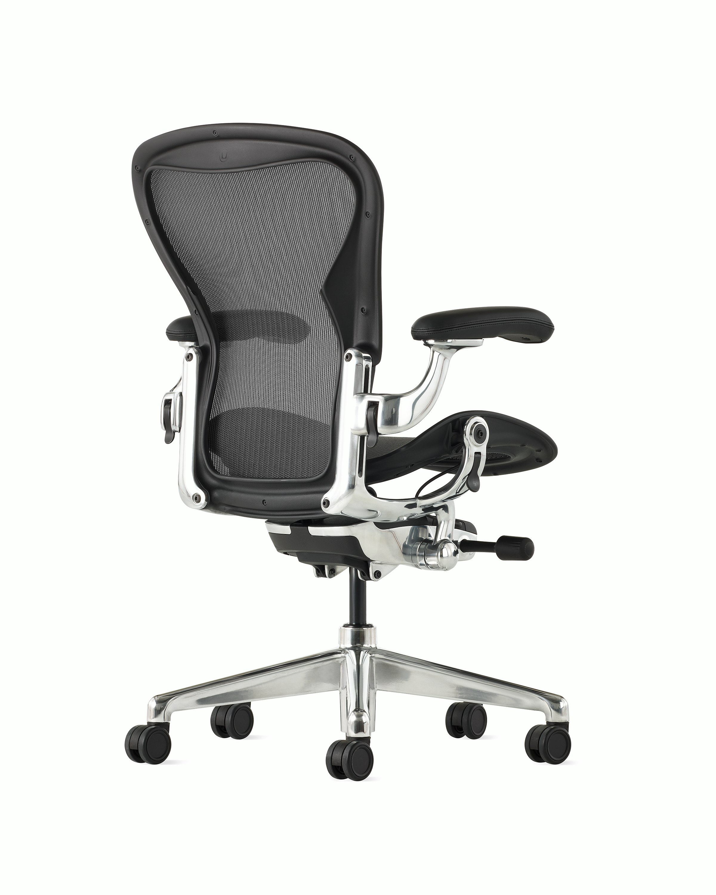 Black matte Aeron Chair on a white background with a polished aluminum 5-star base, chassis, and ergonomic back support, angle view of chair back.