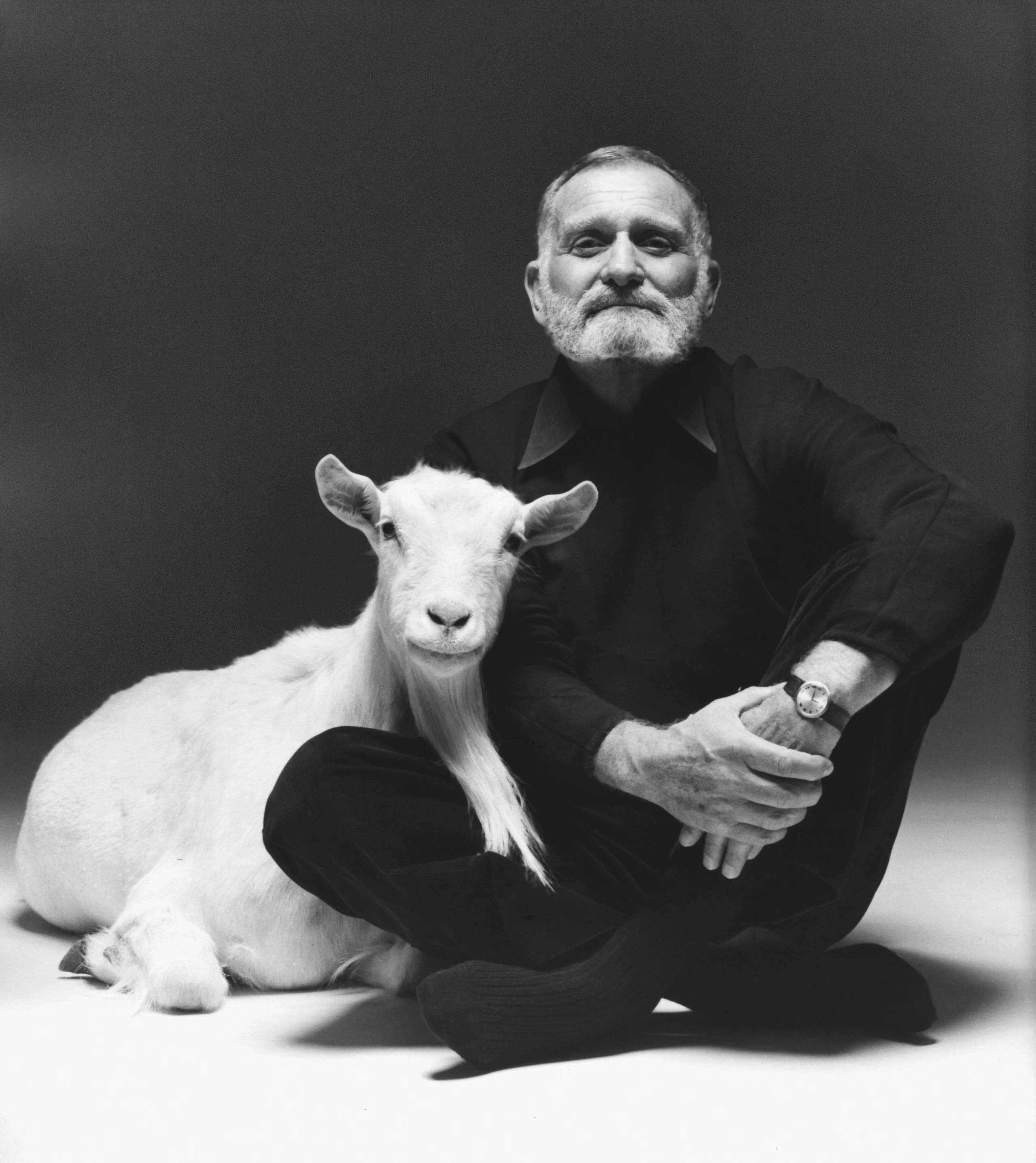 Designer Ward Bennett sitting next to white goat
