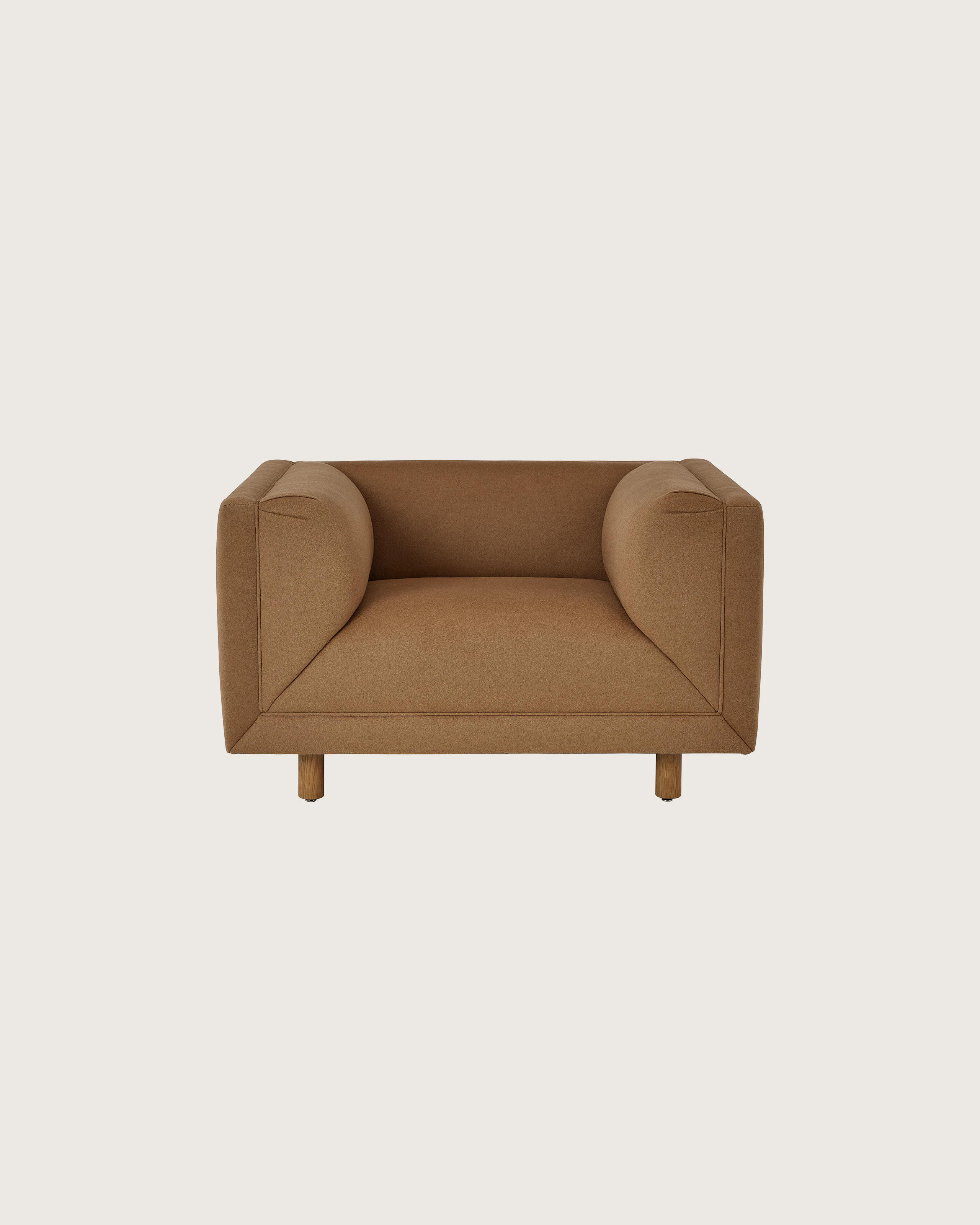 Rolled Arm Club Chair designed by Ward Bennett upholstered in Brushed Camel in Natural with a Natural Oak base, shown front-facing on a white sweep.
