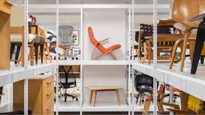 Iconic pieces of furniture from the MillerKnoll collective on display on white shelves at the MillerKnoll Archives