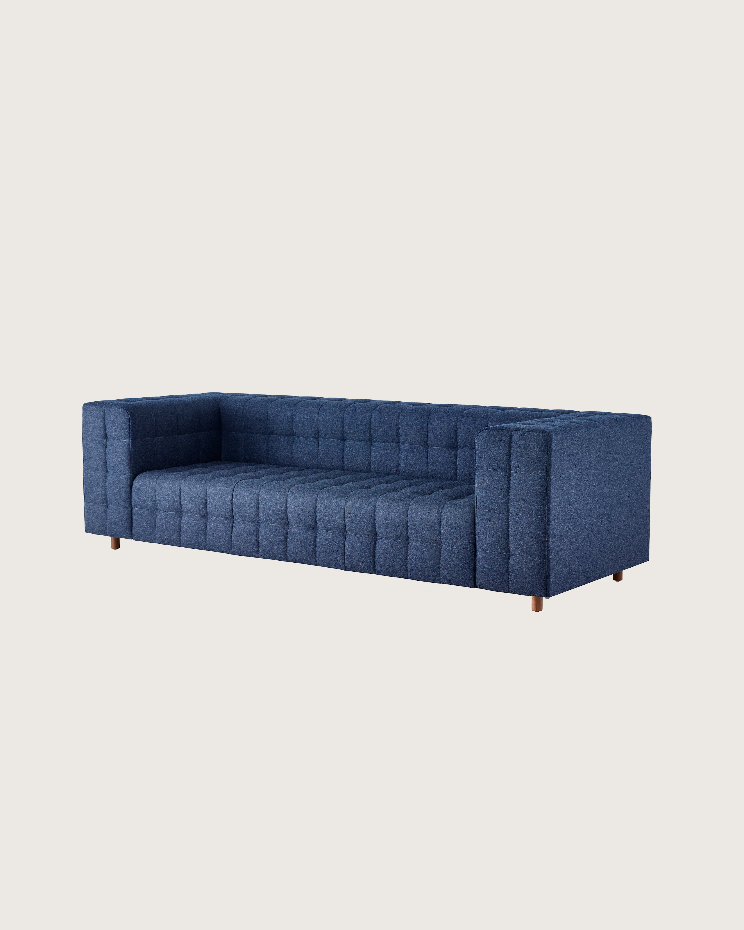 A three-seat Rapport Sofa in a deep navy colored textile, viewed at an angle.