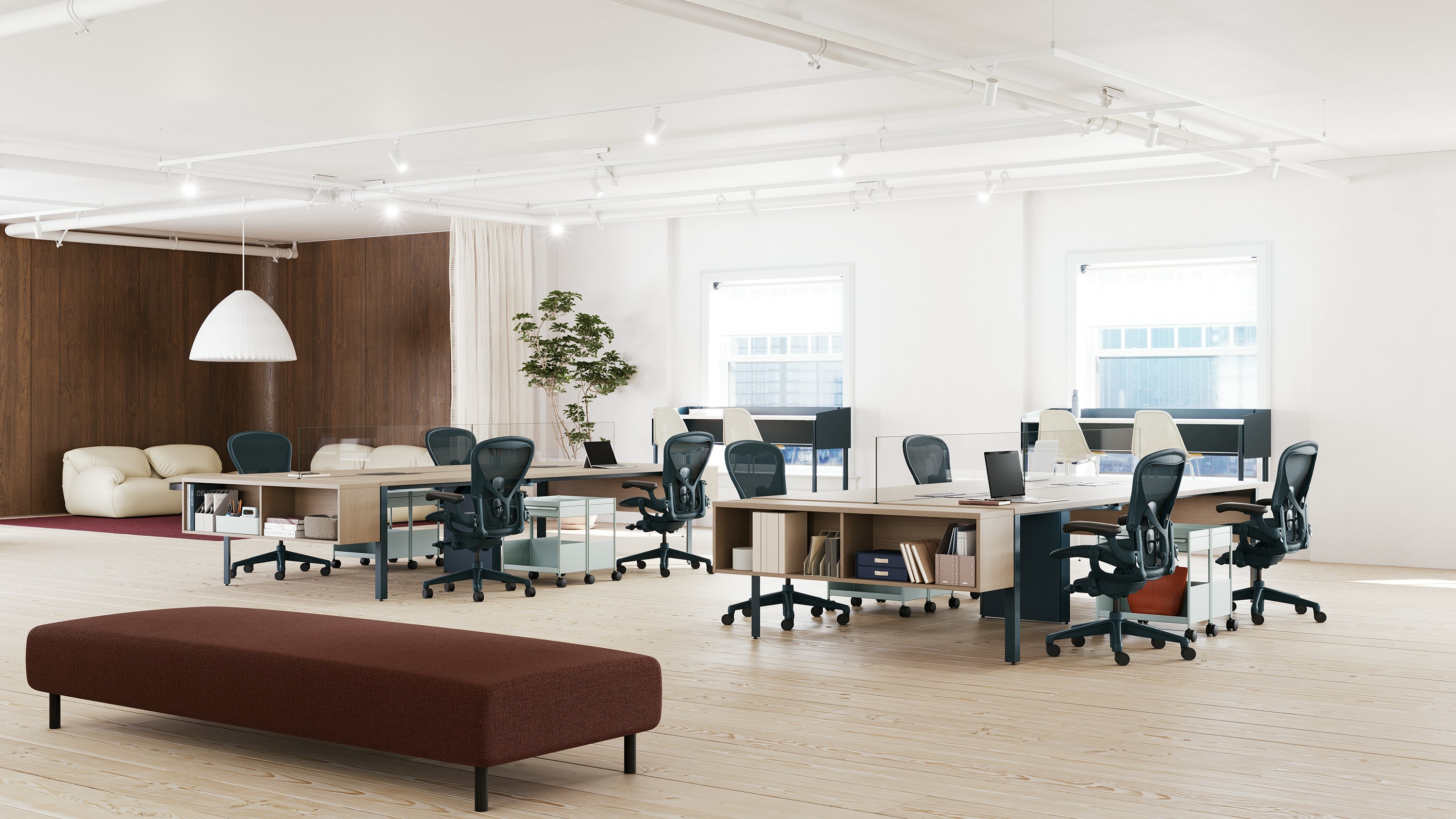 Two sets of workstations, each with six Aeron chairs in dark blue.