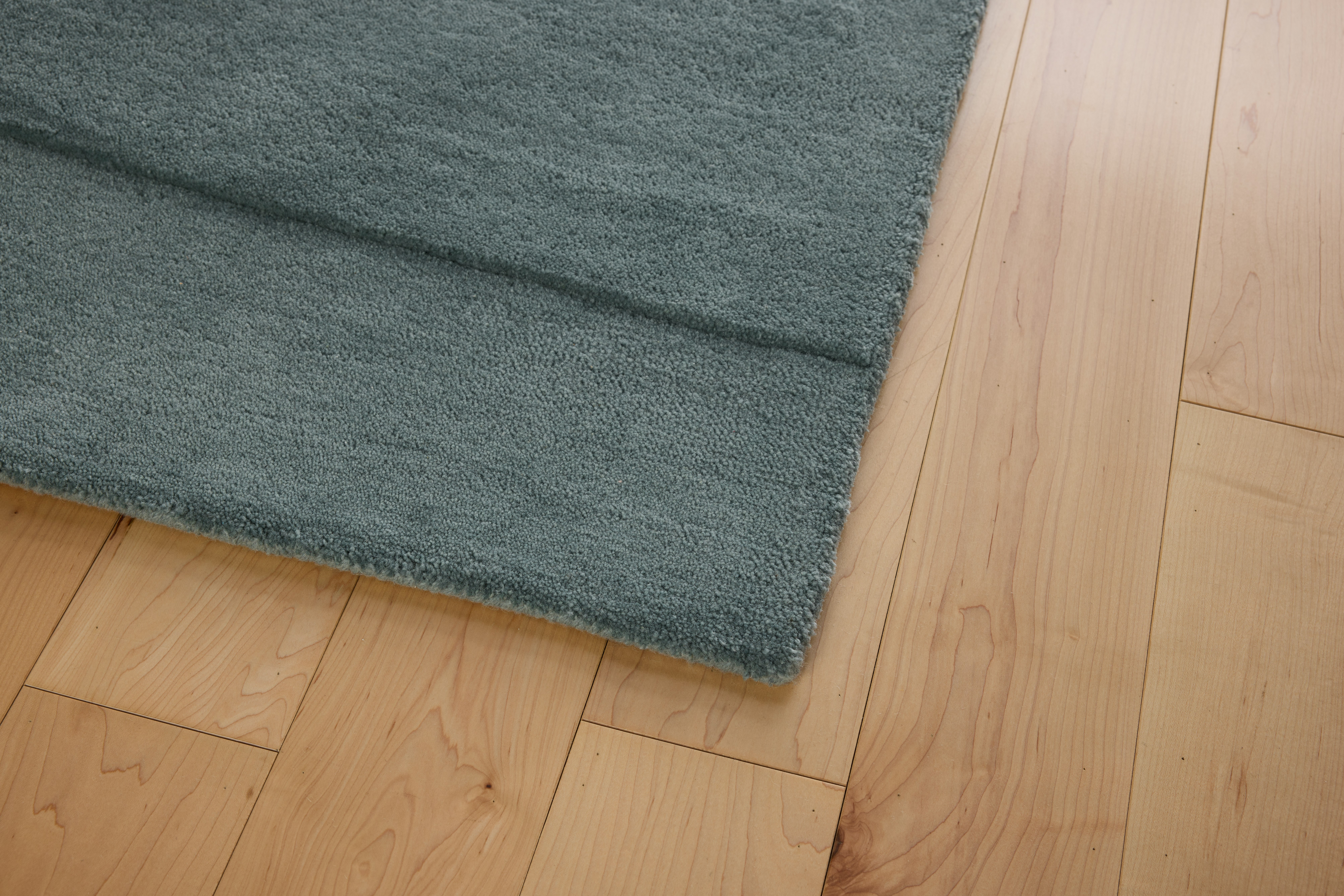 A detailed look at a Simple Curve Rug in Light Blue.