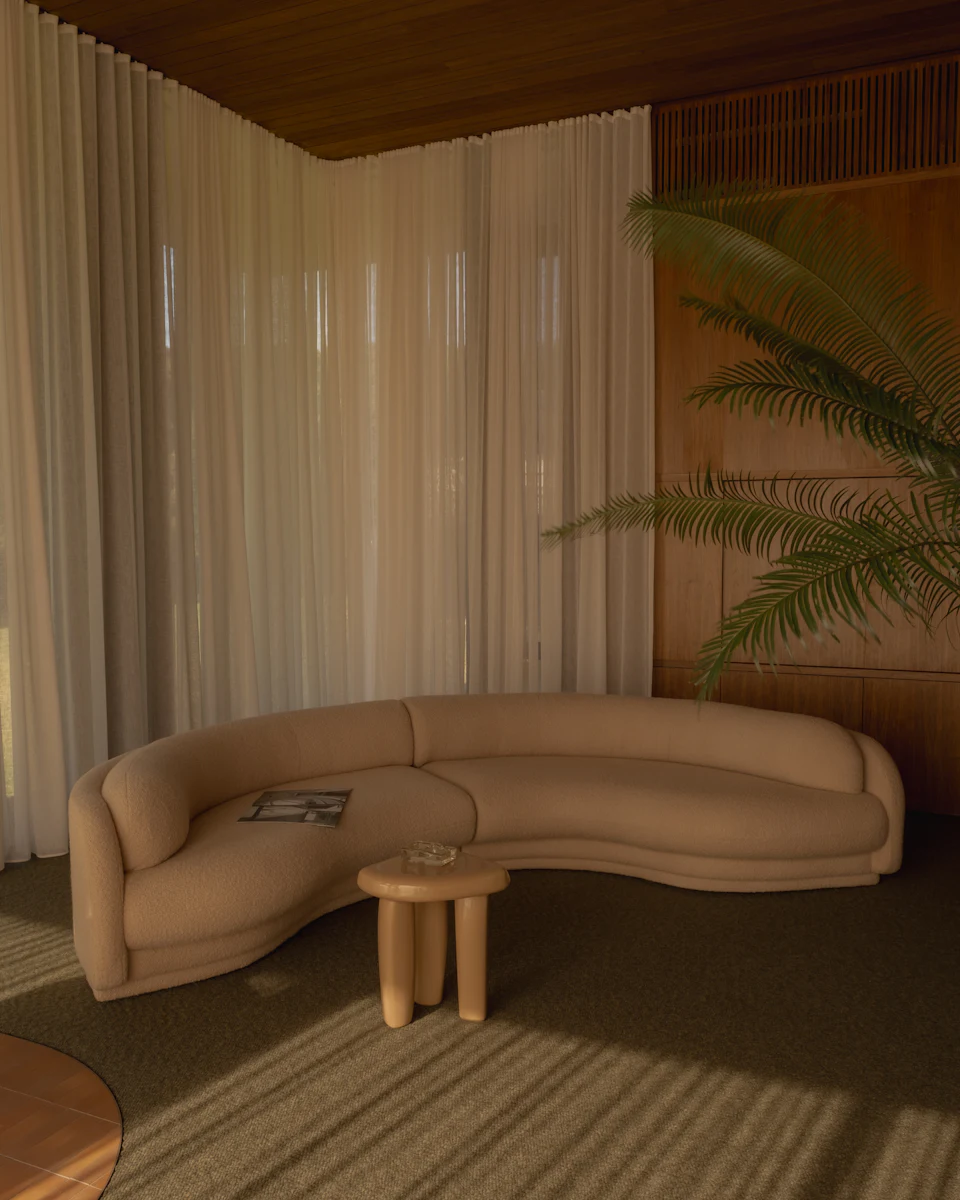 Beige modular sectional sofa in living room with curved design and glass table