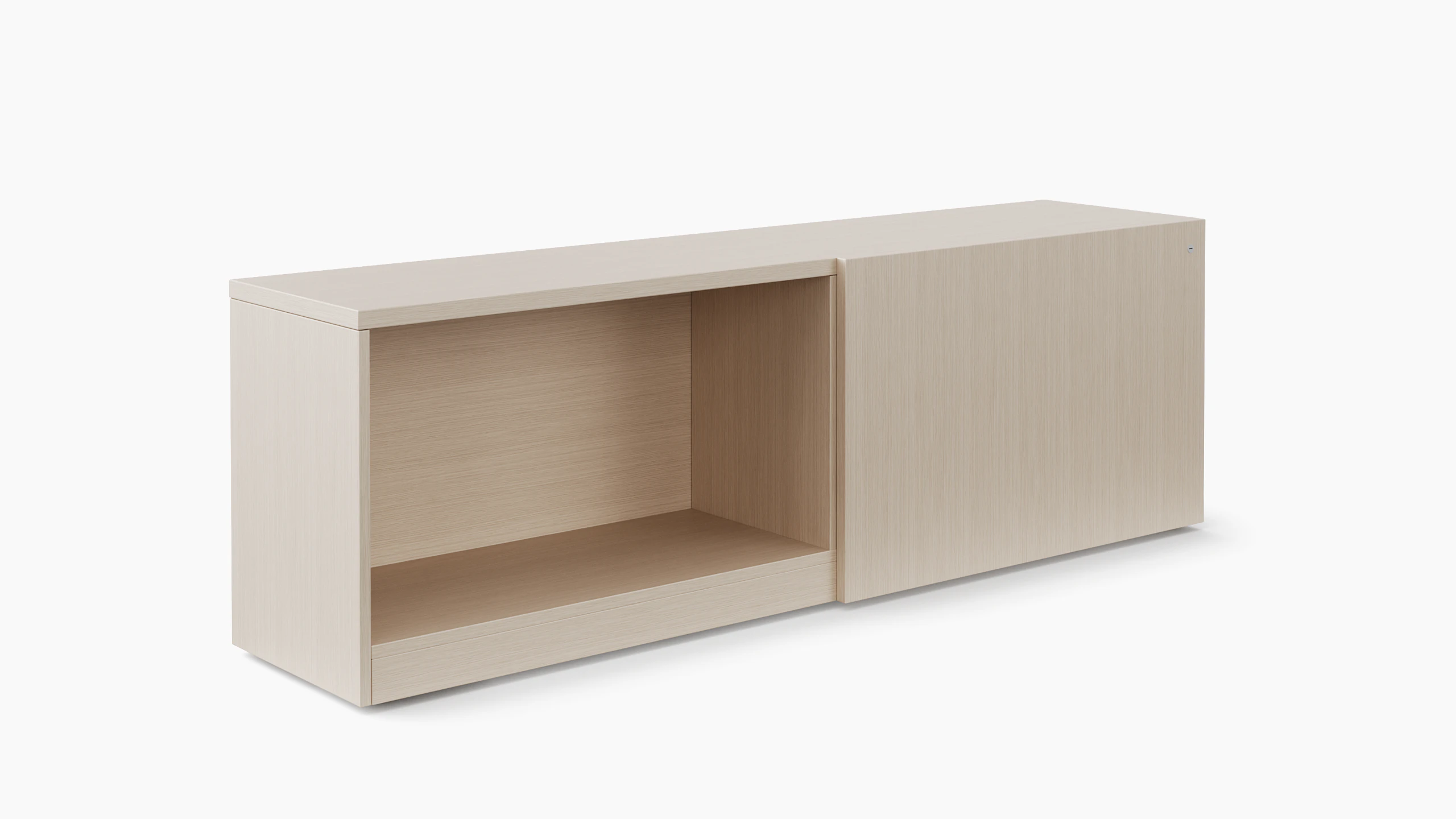 A storage credenza is in a light color veneer and is viewed at an angle.