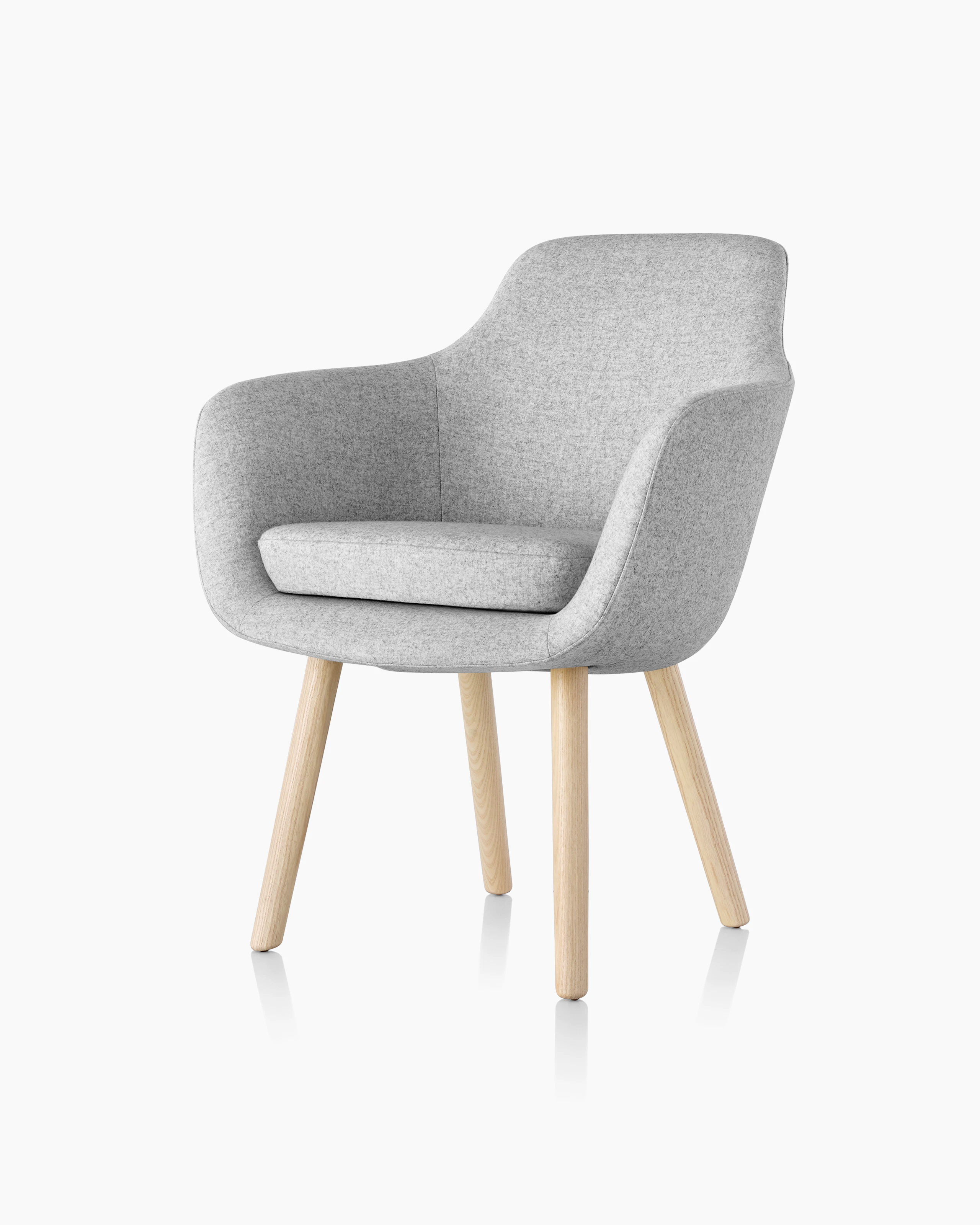 Angled view of a Saiba Side Chair with light gray upholstery and wood legs in a light finish.