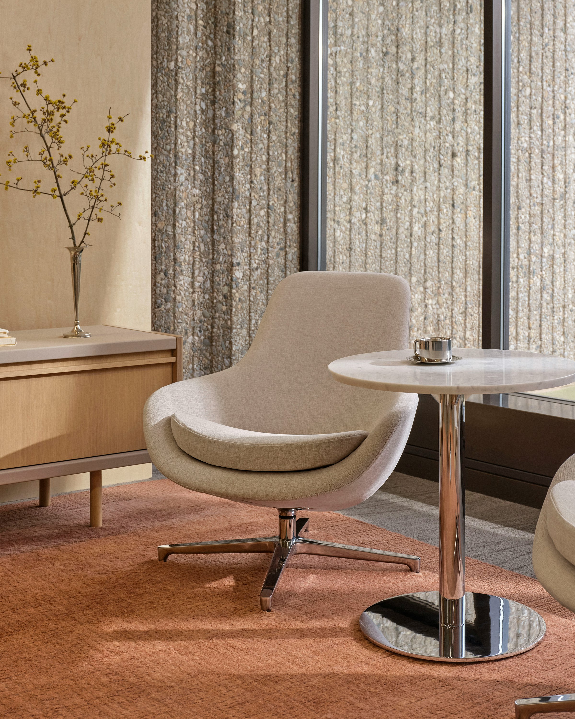 Saiba Lounge Chair upholstered in Vionette in Desert Mix with a polished aluminum base, shown with an NL Side Table and a New Canaan Media Unit in a lounge setting.