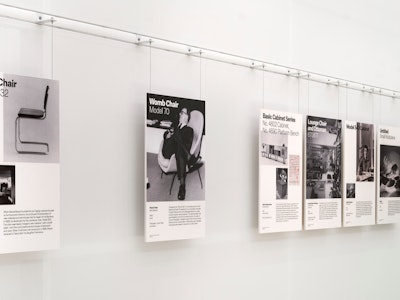 Informational placards for the Cesca Chair, Womb Chair, Eames Lounge Chair and Ottoman, and more on a wall display at the MillerKnoll Archives