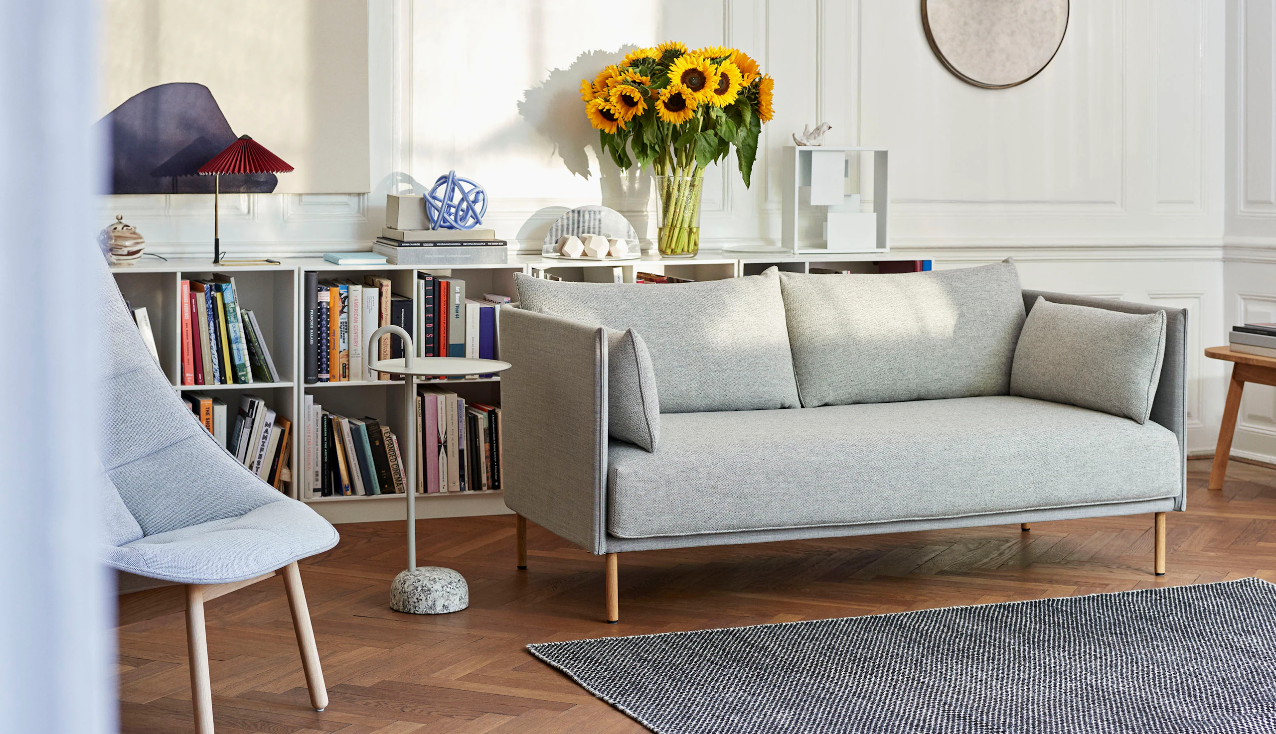 A Bowler Table next to a grey Silhouette Sofa.