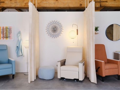 Several Nemschoff healthcare recliners, one blue, one white, and one orange, in three displays at the MillerKnoll healthcare showroom at Design Days