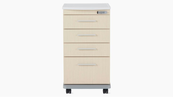 Front view of a Mora casework four-drawer supply cart in a light ash finish and a white solid surface top.