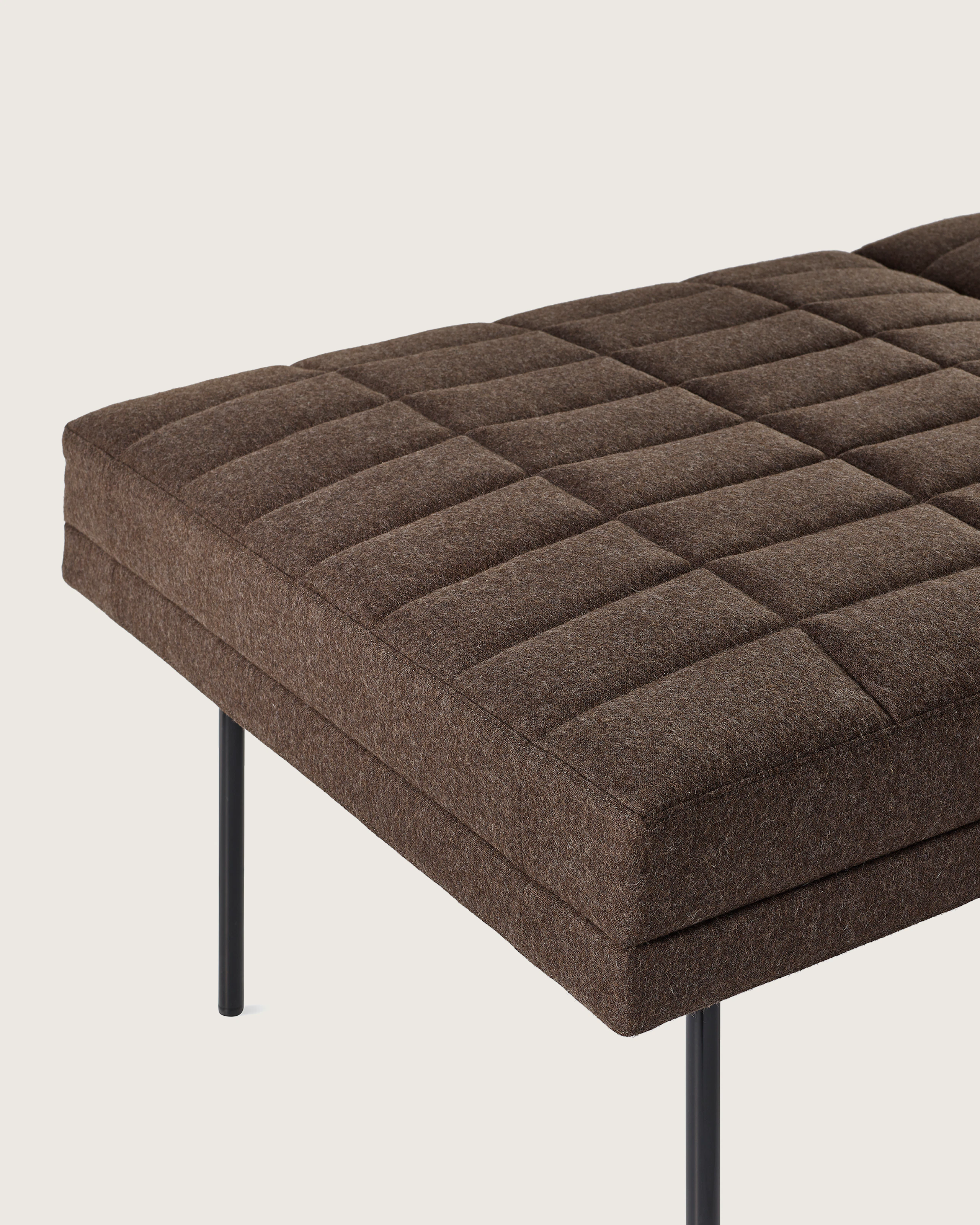 Detail shot of Tuxedo Component Lounge Bench upholstered with Panno di Dolce textile in Umber and black metal legs viewed from an angle.
