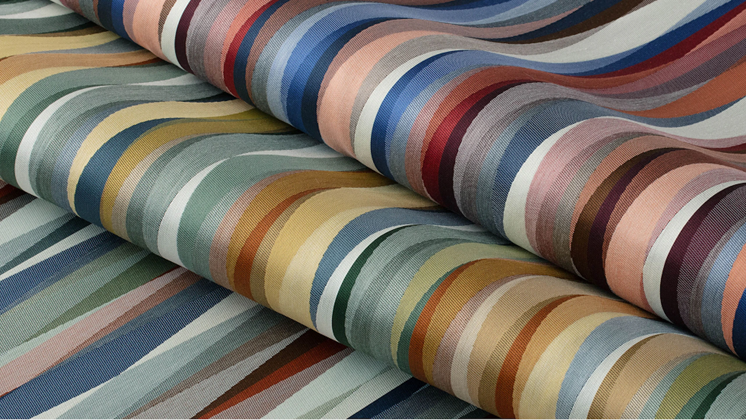 Several multicolored layers of the Overlay Stripe material from Maharam.