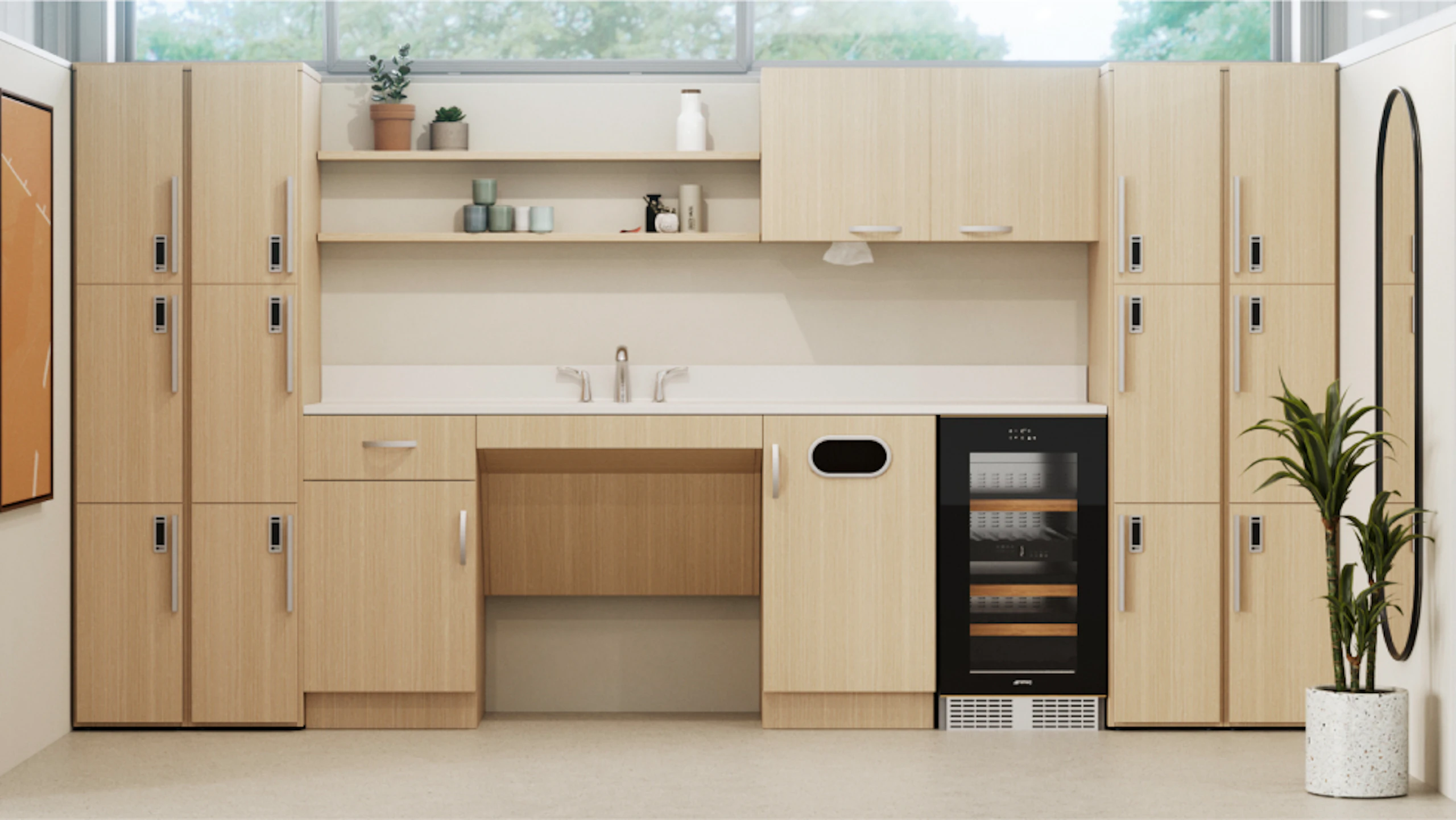 Modern kitchenette with light wood cabinets, white countertop and sink, and a beverage cooler. Lockers flank the cabinets on both sides. A potted plant adds a touch of greenery.