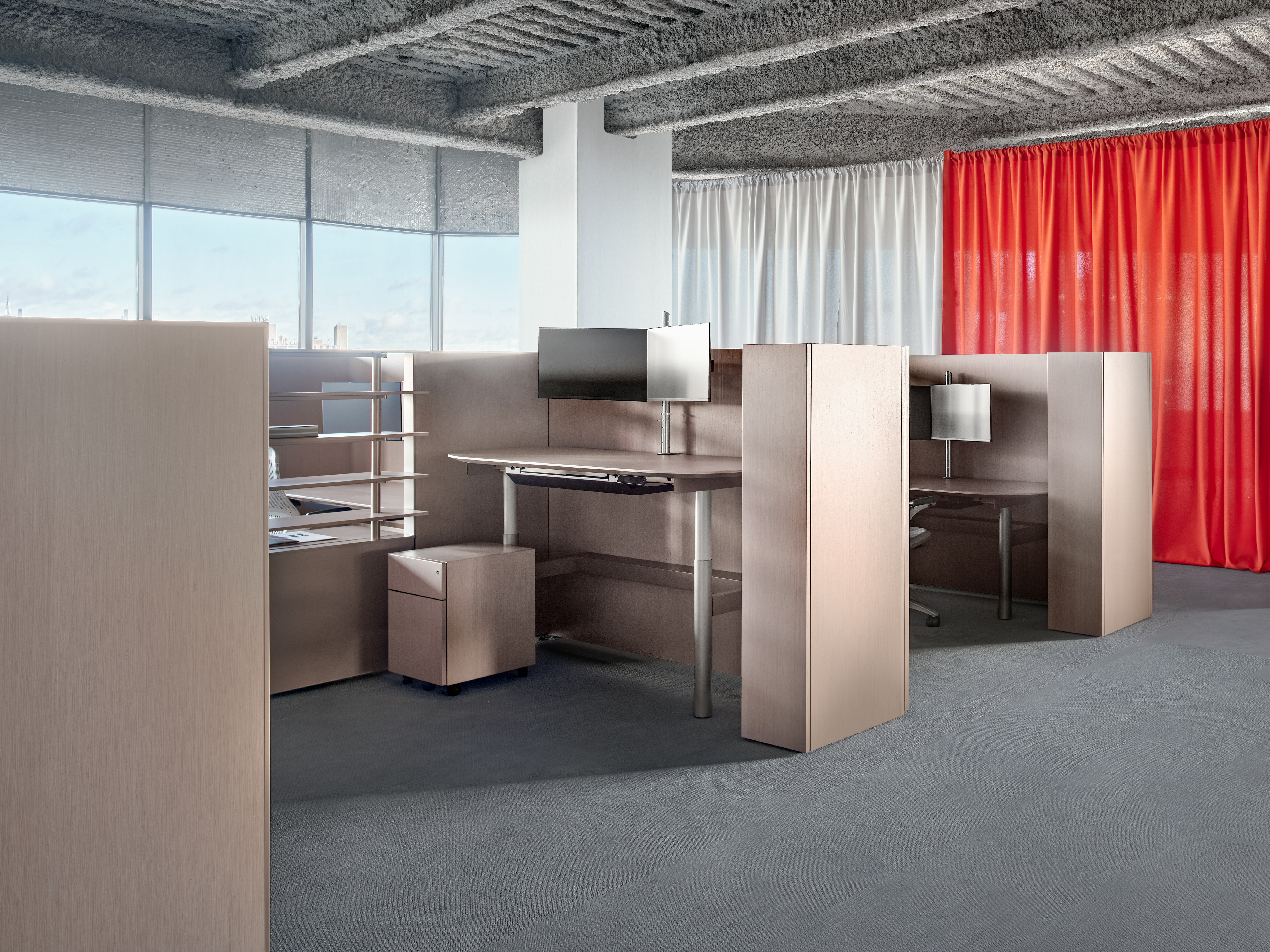 A group of workstations viewed from an angle. The workstations have high panels, open shelves, personal storage as well as a small locker.