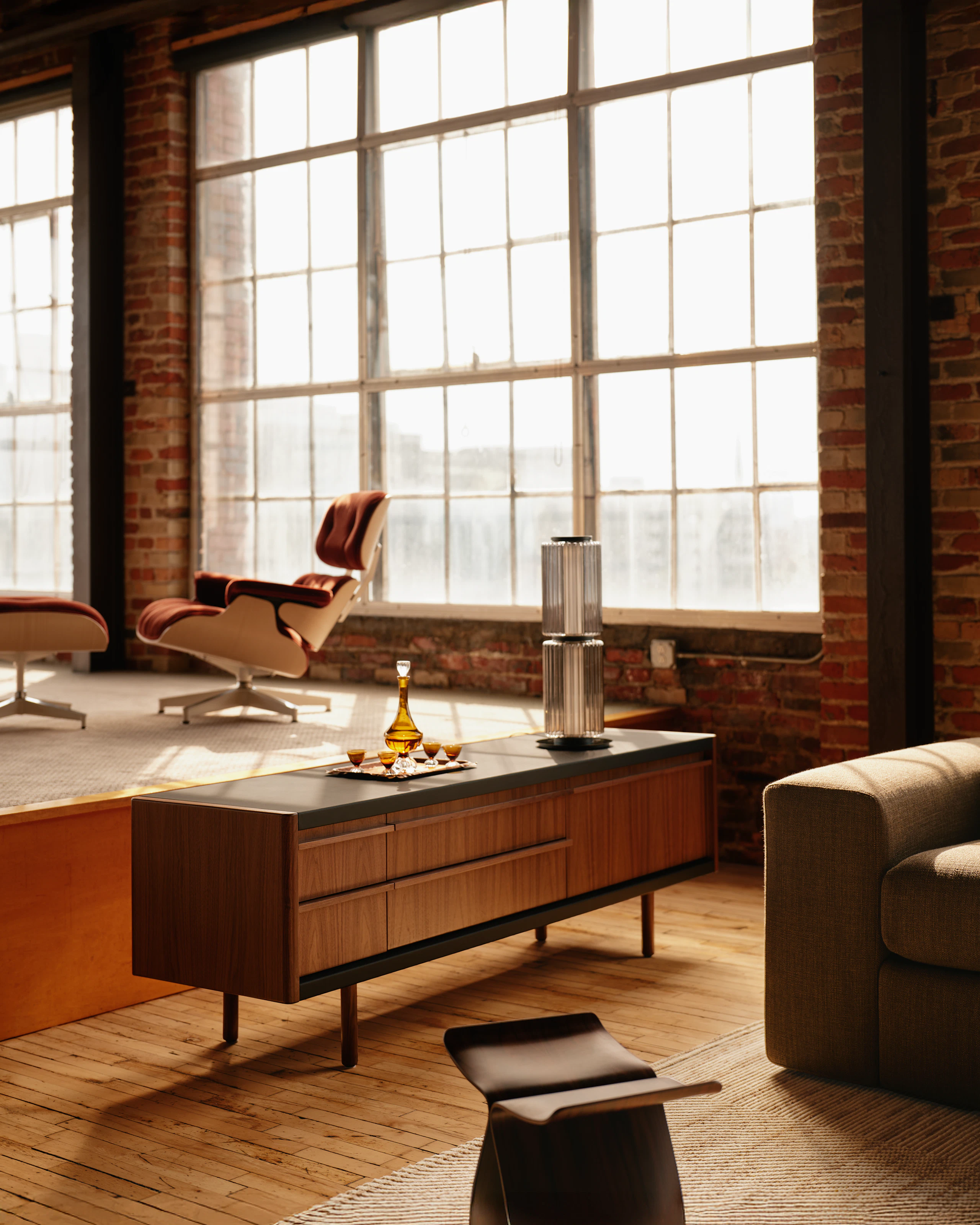 New Canaan Media Unit designed by BassamFellows for Geiger in Walnut with Black Leather shown angled in a residential setting.