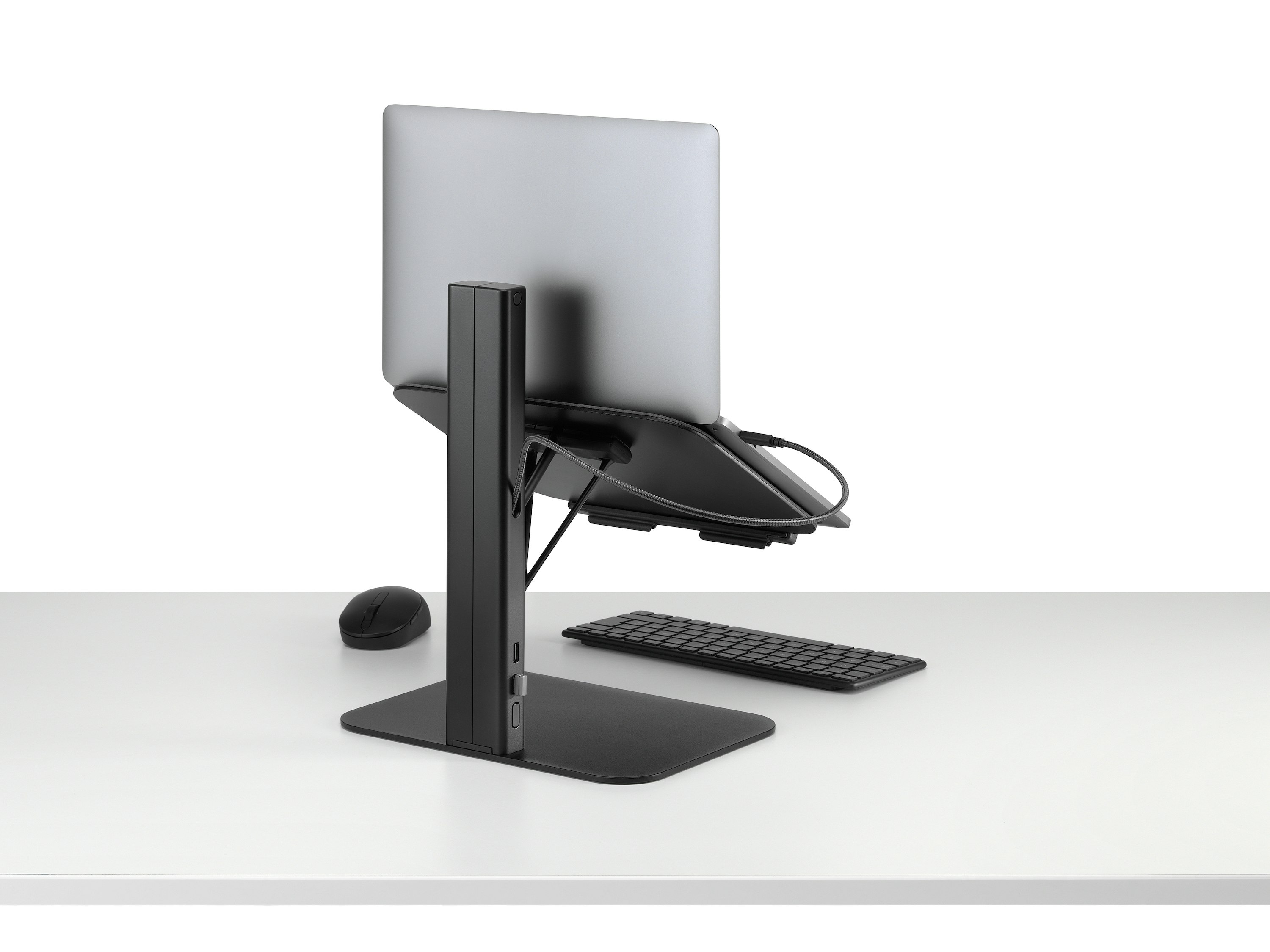 Lana laptop stand with laptop keyboard and mouse in black viewed from a back sided angle.