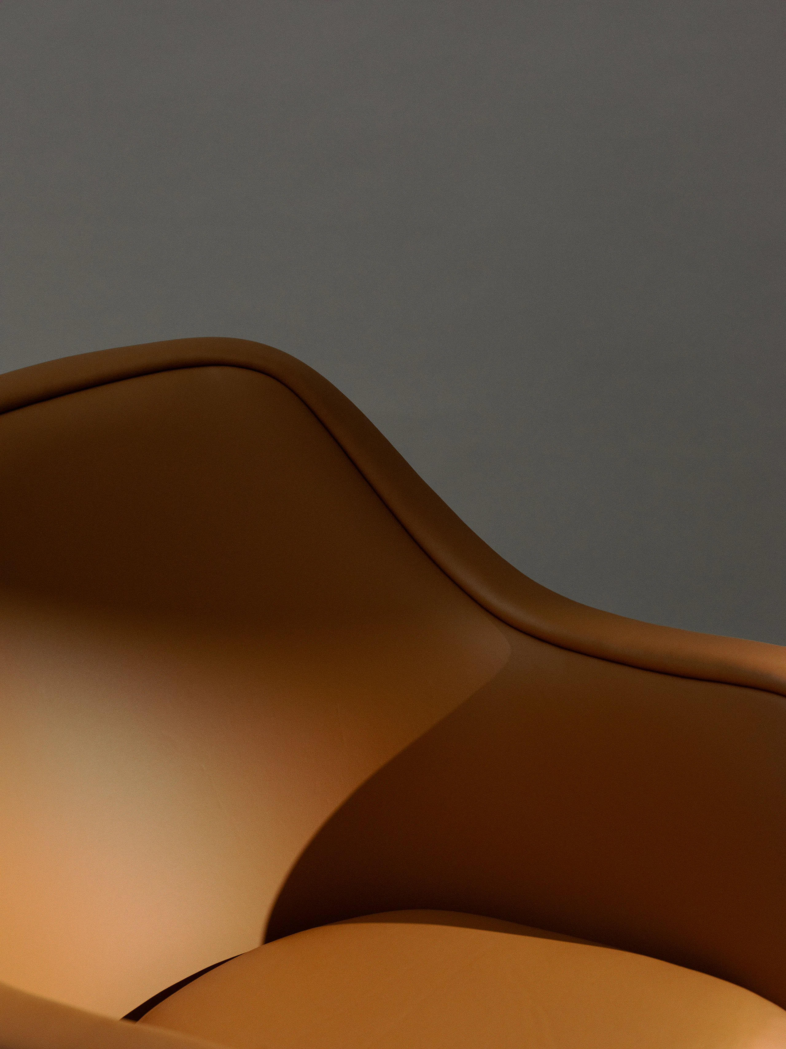 Detail view of a Bumper Lounge Chair with low arms upholstered with Pace Leather in Toffee.