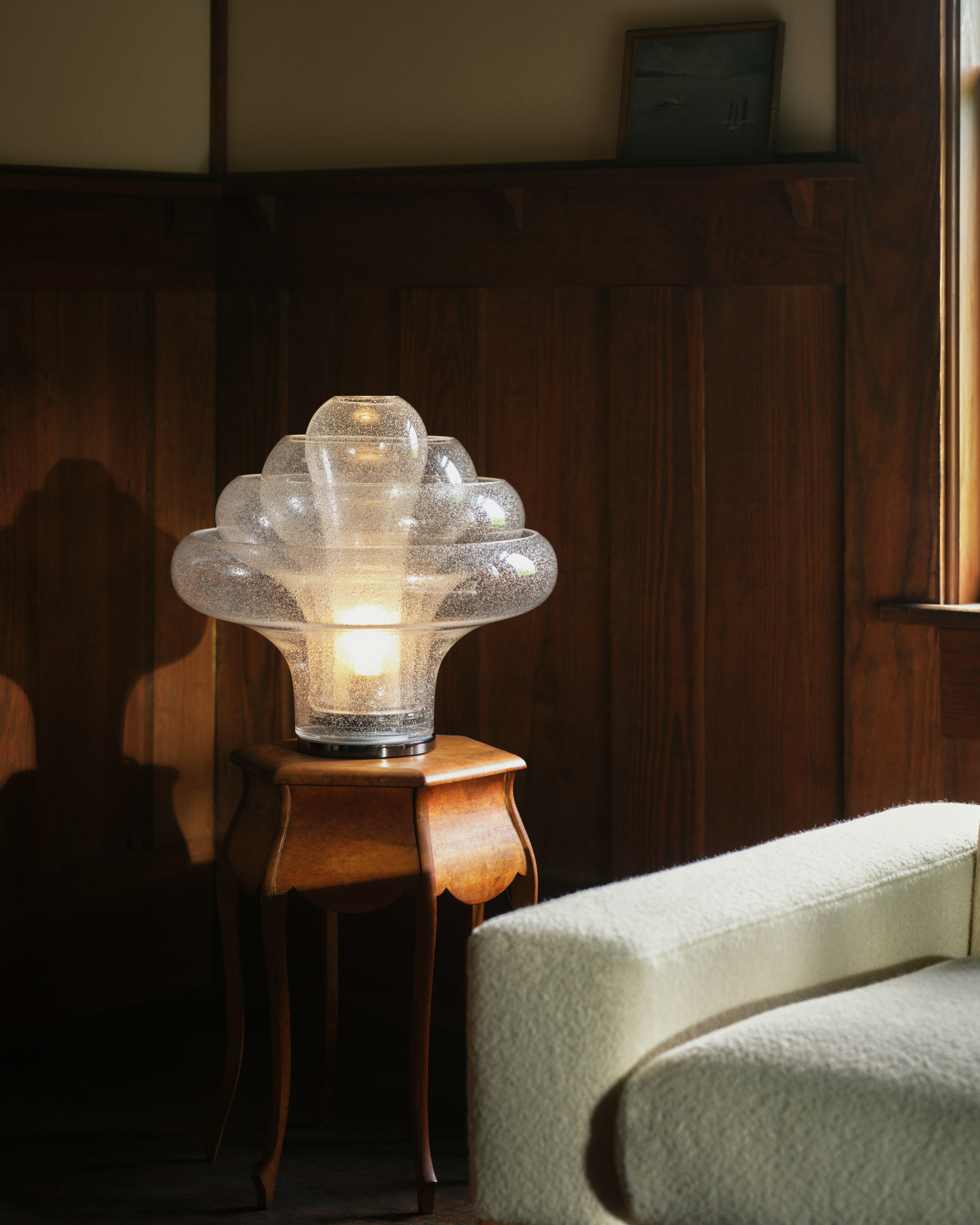 Lotus Table Lamp on a side table next to an ivory sofa with light on