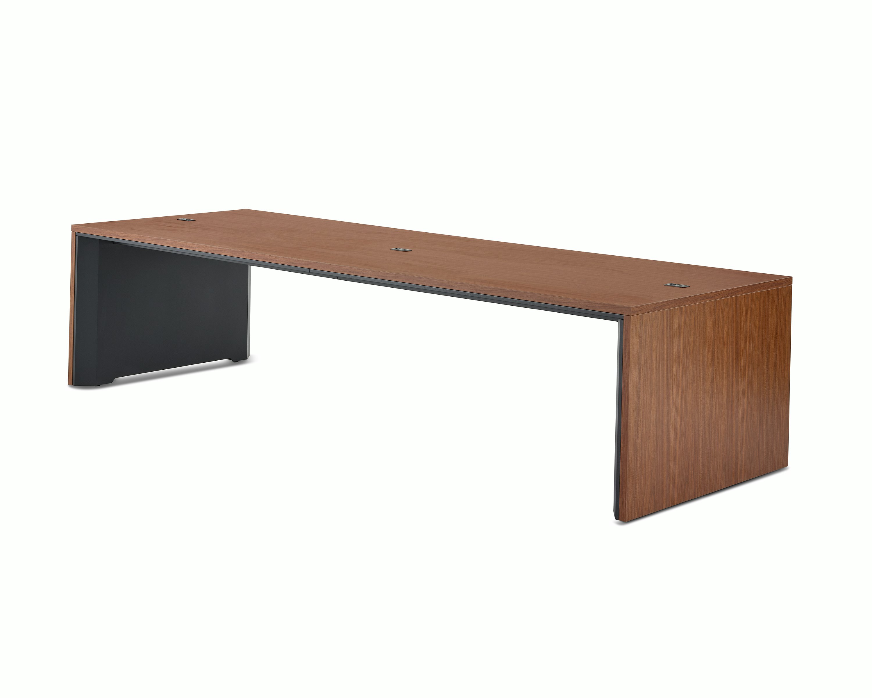 A wide communal Headway table at seated height with a medium wood top and black base viewed at a 45-degree angle.