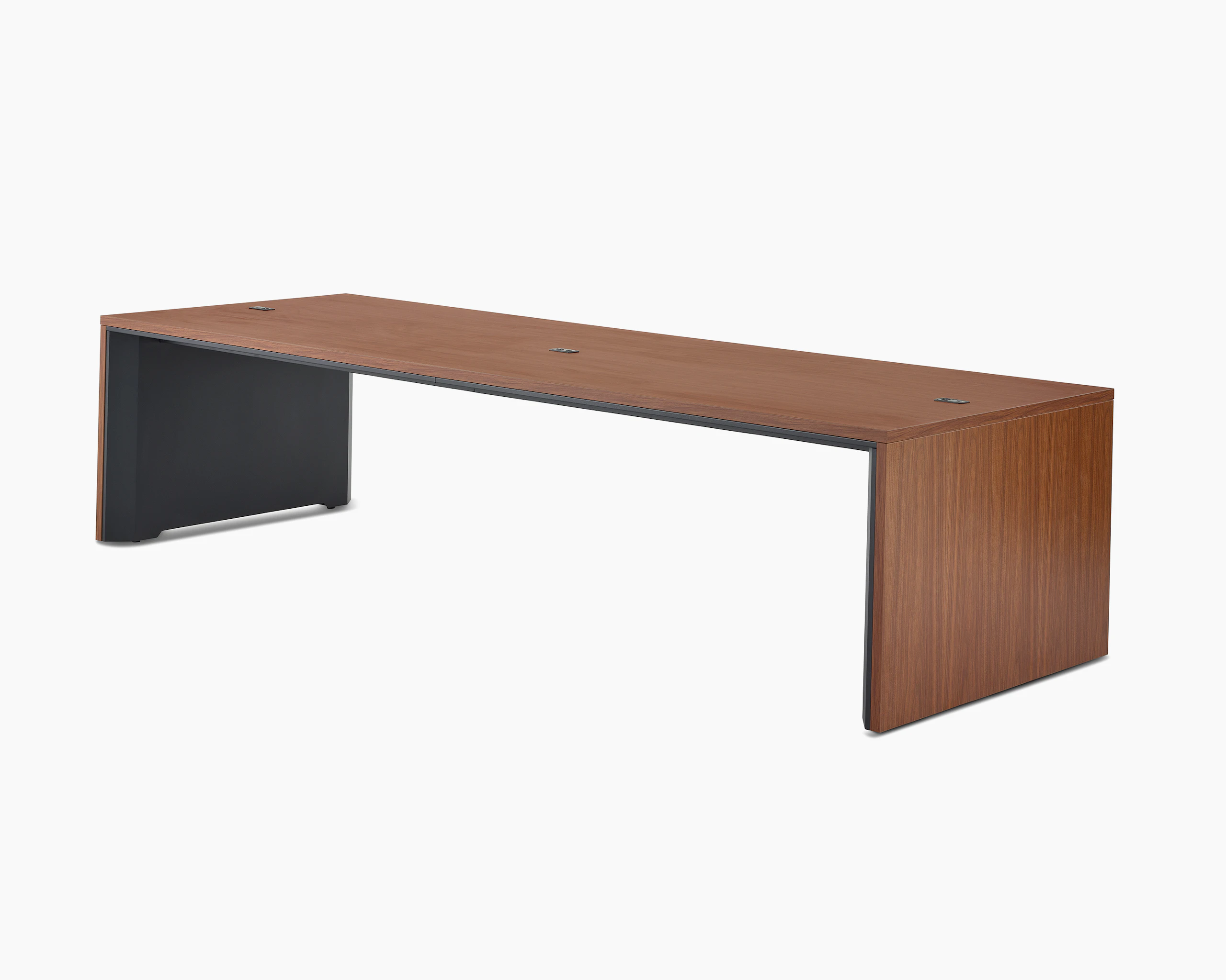 A wide communal Headway table at seated height with a medium wood top and black base viewed at a 45-degree angle.