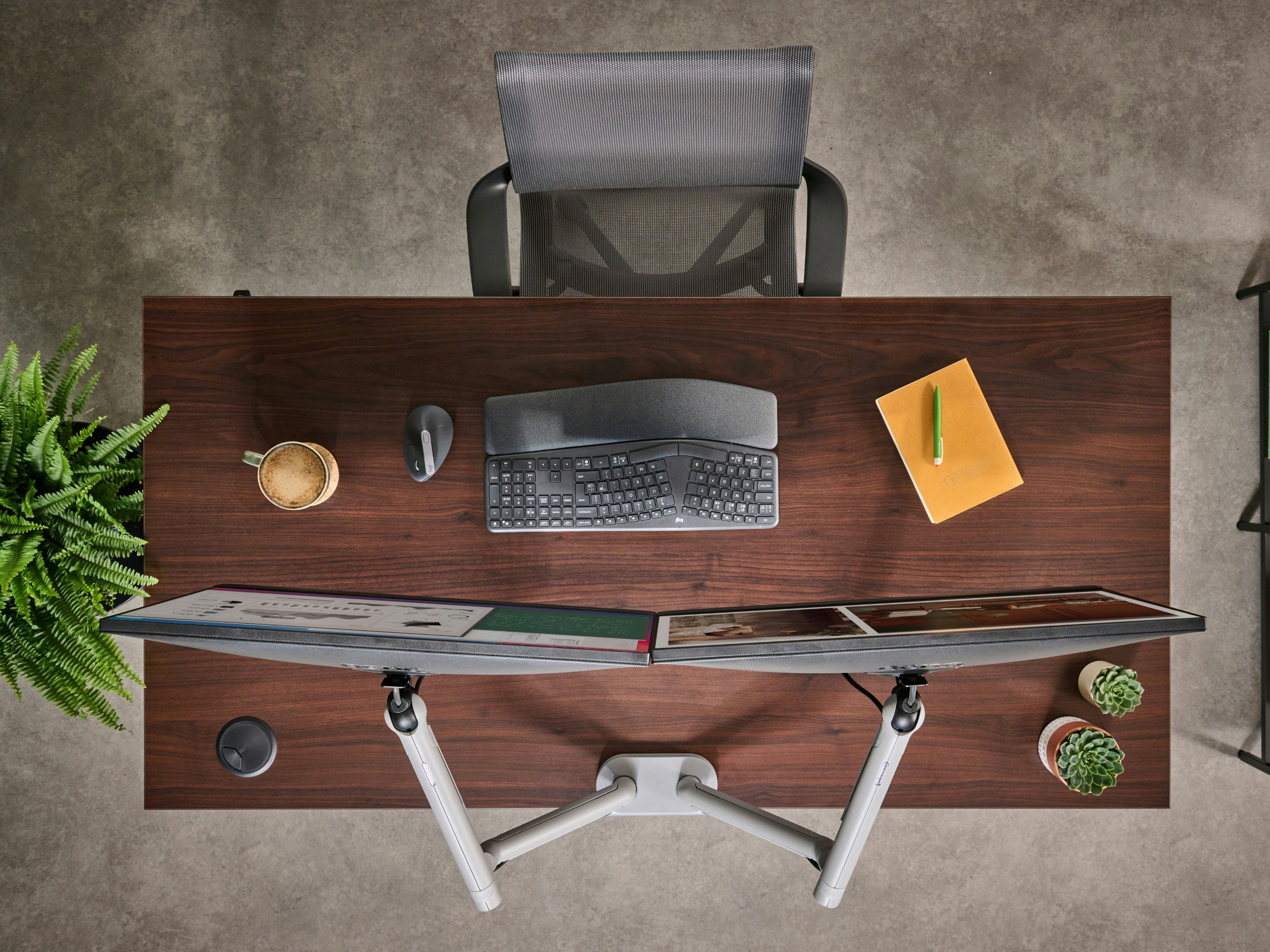 Desk with silver Flo Dual monitor arm in a working environment.