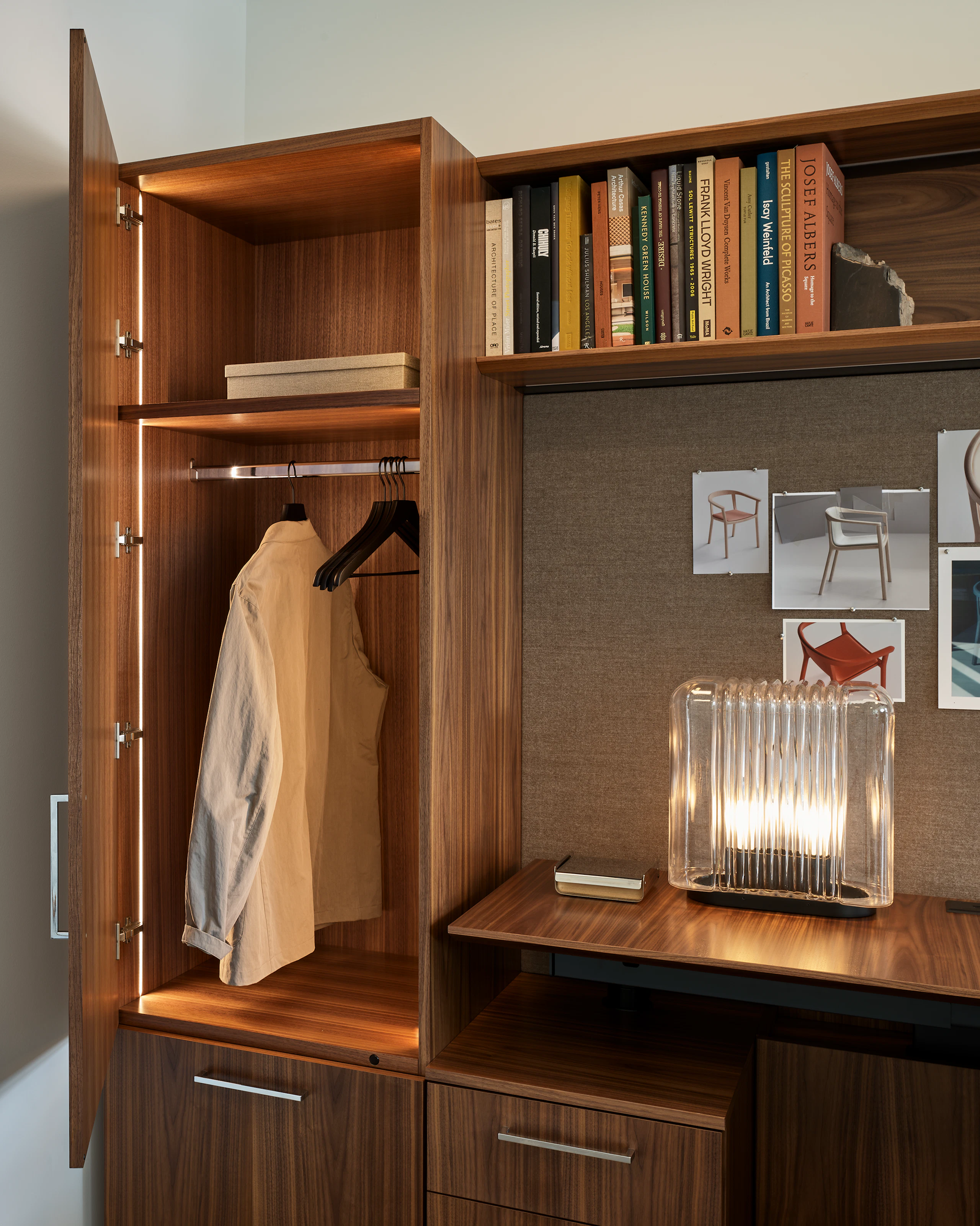 Detail view of a Geiger One Casegoods Private Office open vertical wardrobe storage in Natural Flat Cut Walnut, viewed at an angle in a private office setting.
