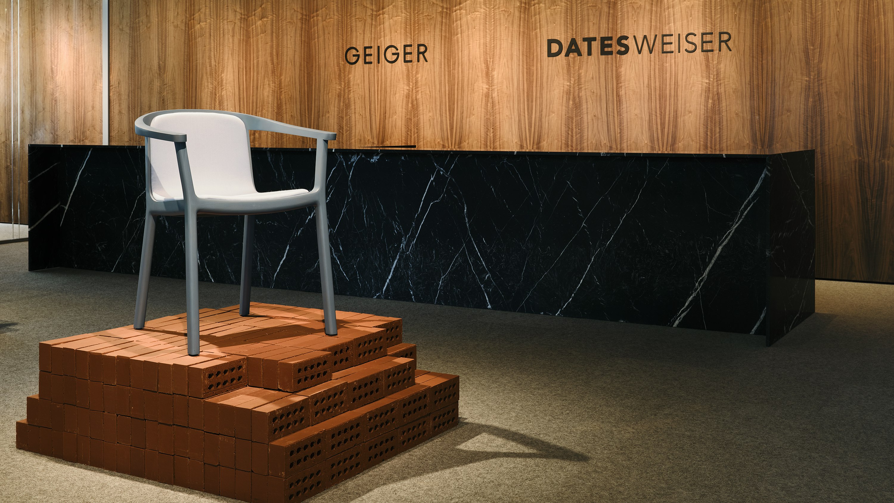 Lijn Armchair designed by Carole Baijings for Geiger in Nordic Blue wood with Maharam Luce upholstery in Brine shown at an angle on an exhibition platform in the Geiger showroom.