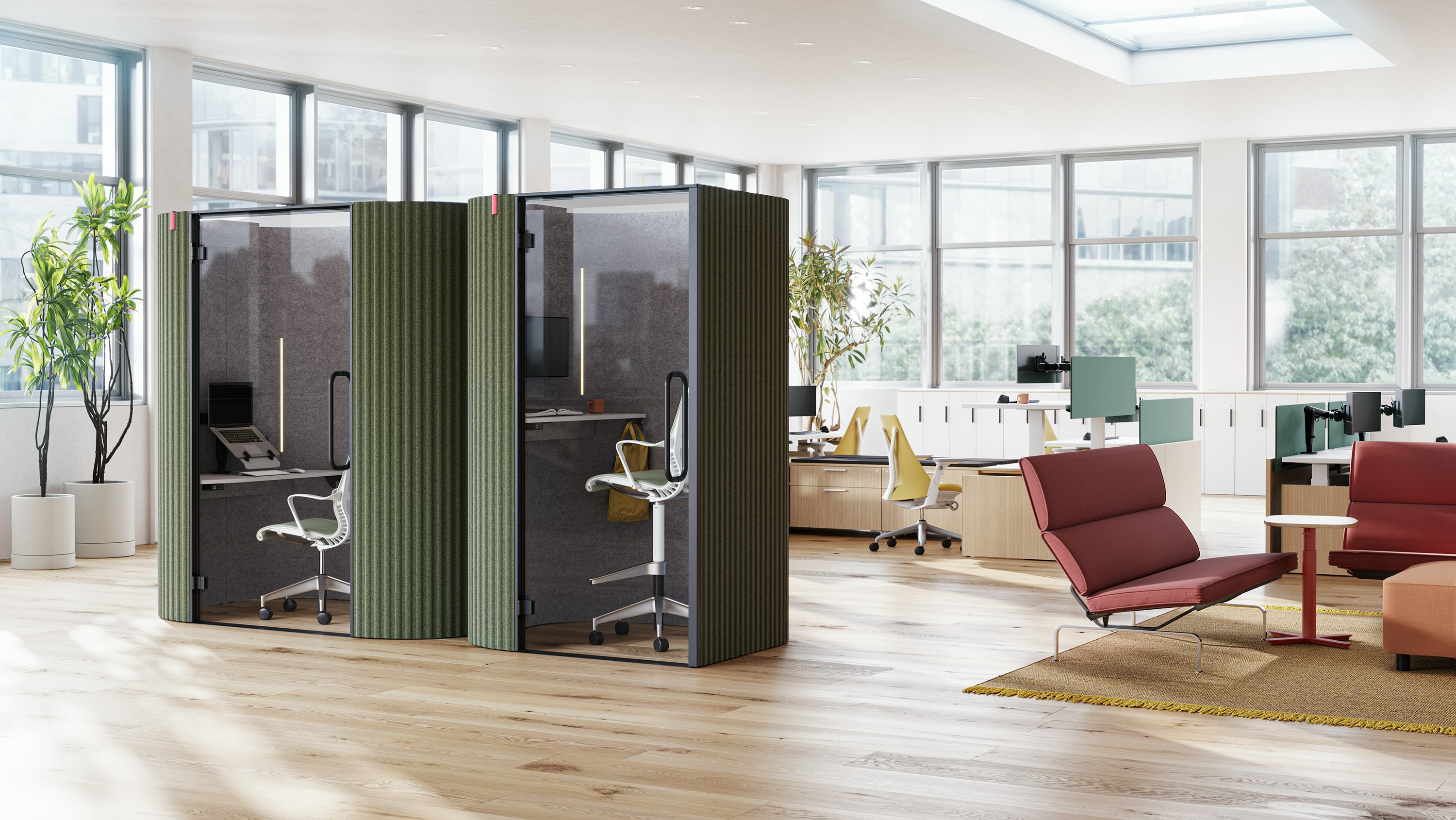 A side-by-side view of Bay Work Pod and Bay Work Pod Pro with workstations in the background and lounge setting off to the right.