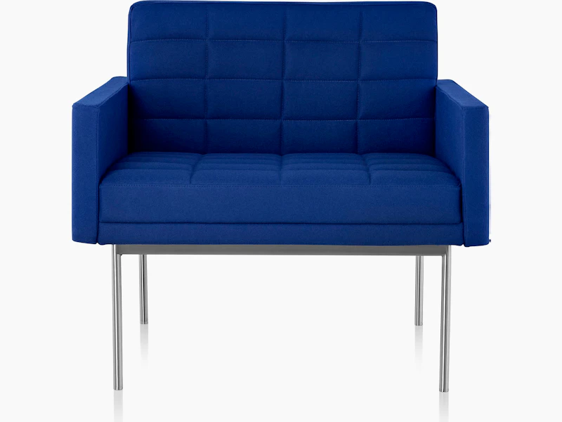 A quilted Tuxedo Component club chair upholstered in blue fabric, viewed from the front.