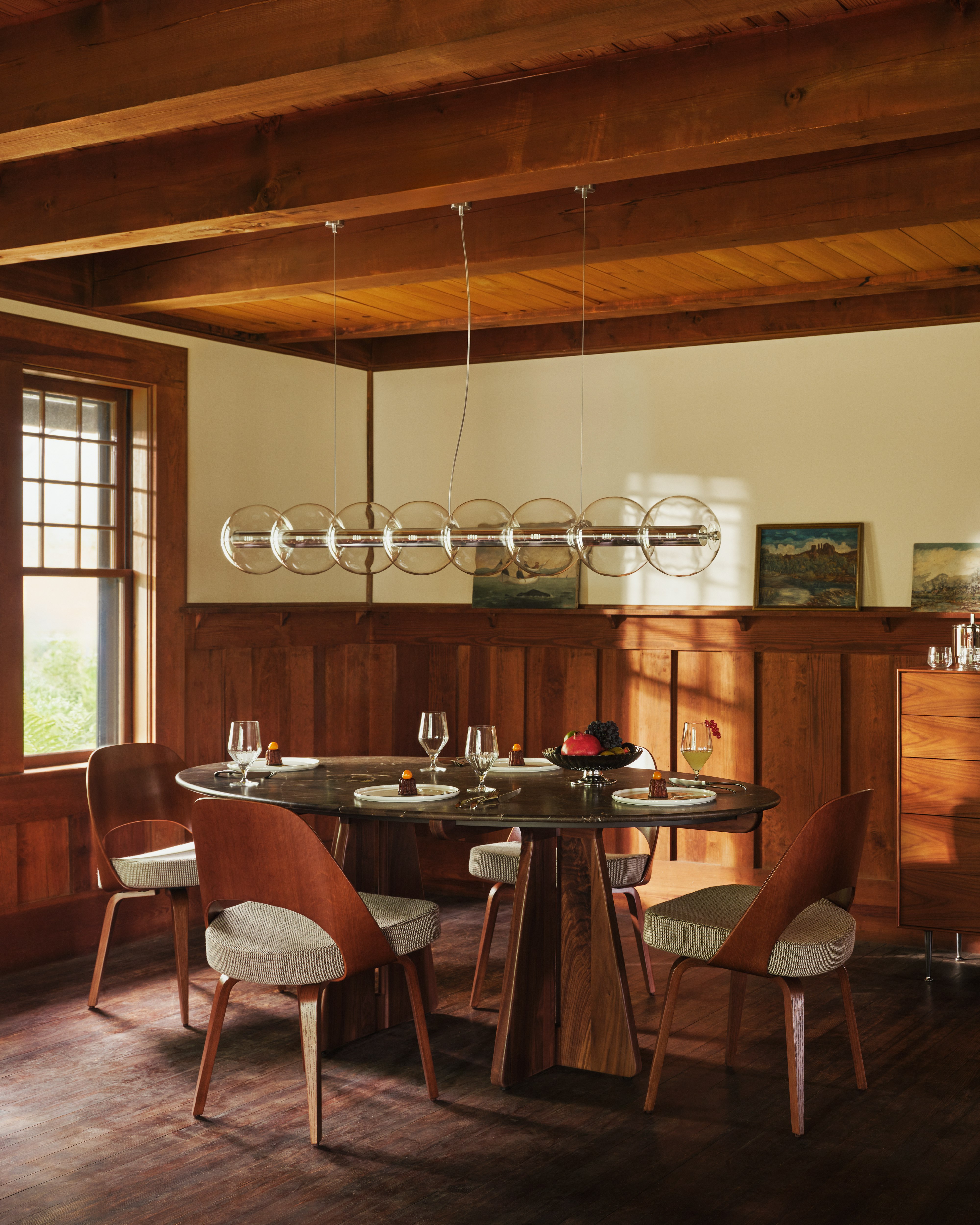 Pinna Dining Table in espresso with Saarinen Veneer Back and Sferica Pendant in a dining room
