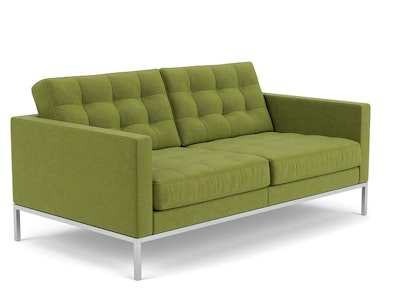 A front three quarter view of a green, two-seat Florence Knoll Sofa by Knoll on a white background