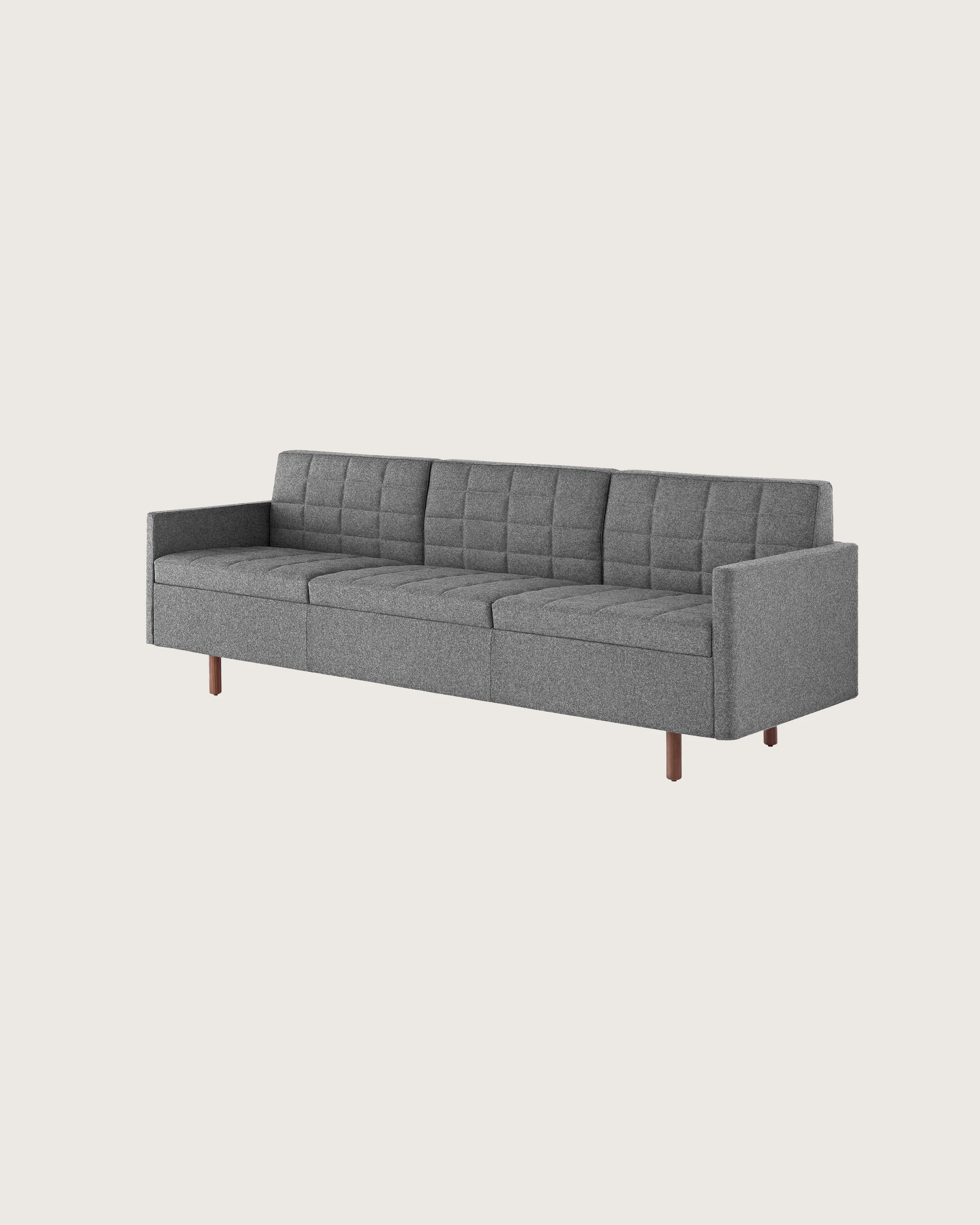 Angled view of a Tuxedo Classic sofa with dark gray quilted upholstery.