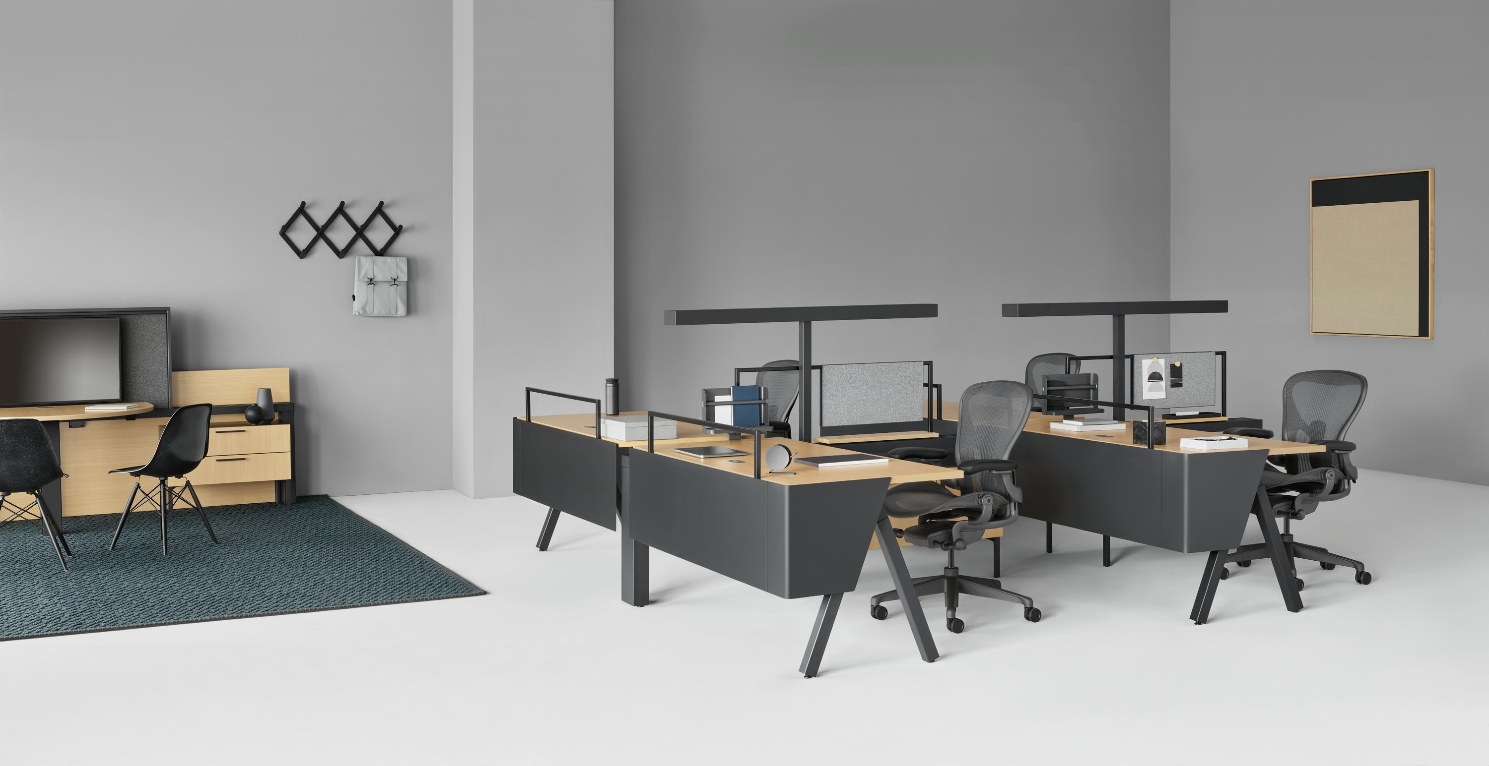 Canvas Vista workstations with black Aeron chairs in the foreground and Canvas Vista collaborative space with display unit in the background.