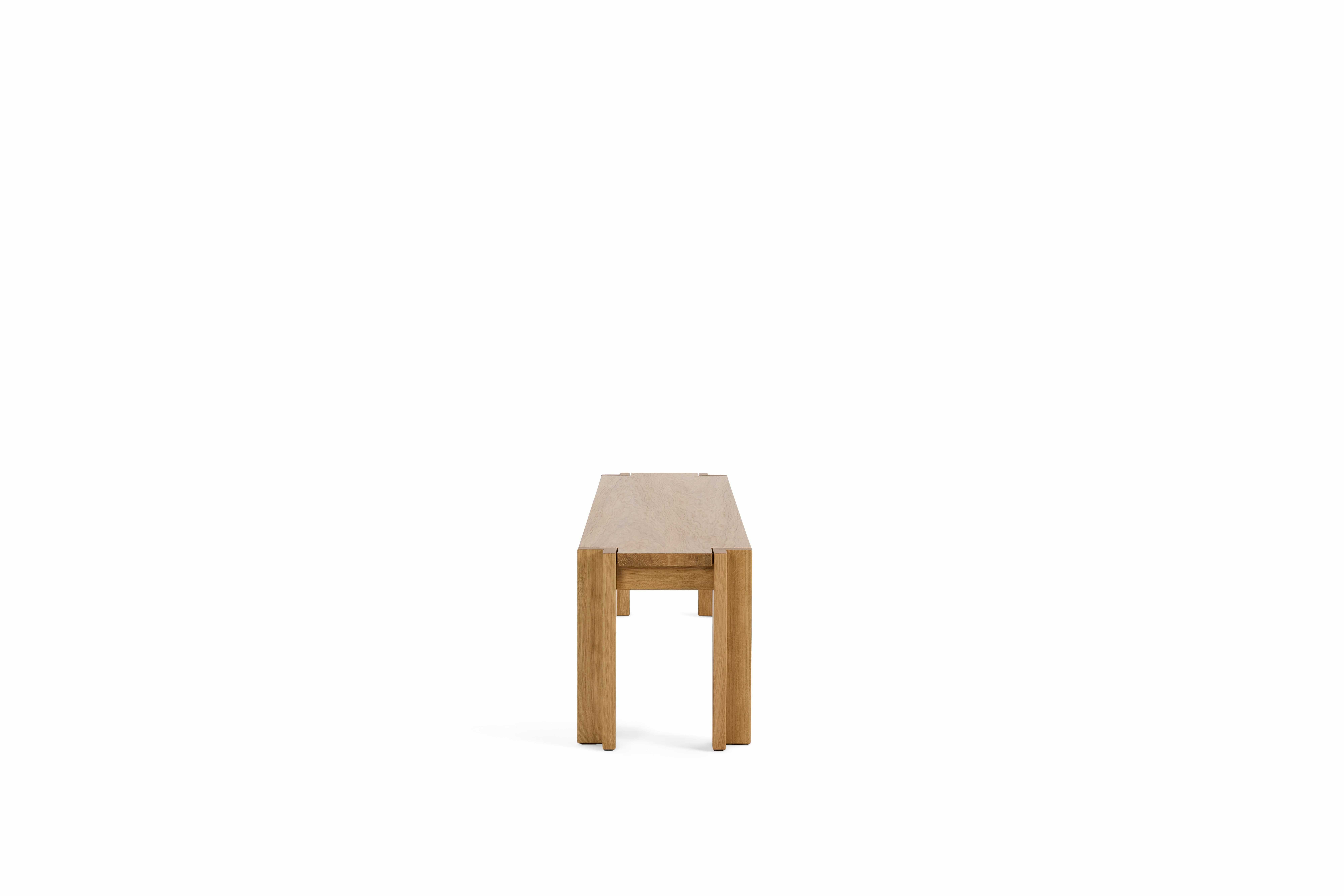 A Utzon Dining Bench in Oak viewed from the side.