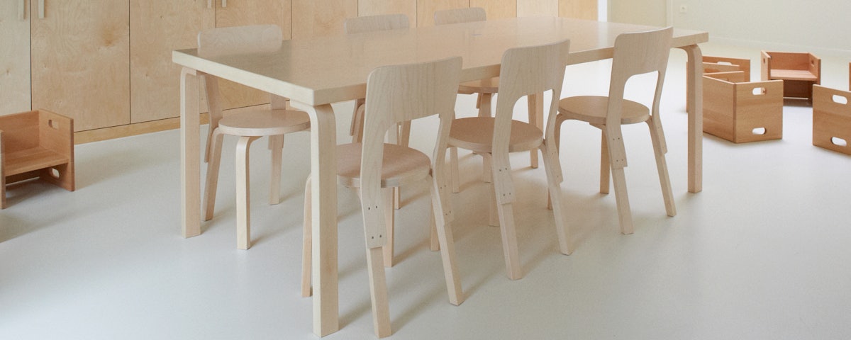 L-Leg Table surrounded by dining chairs in a dining room setting