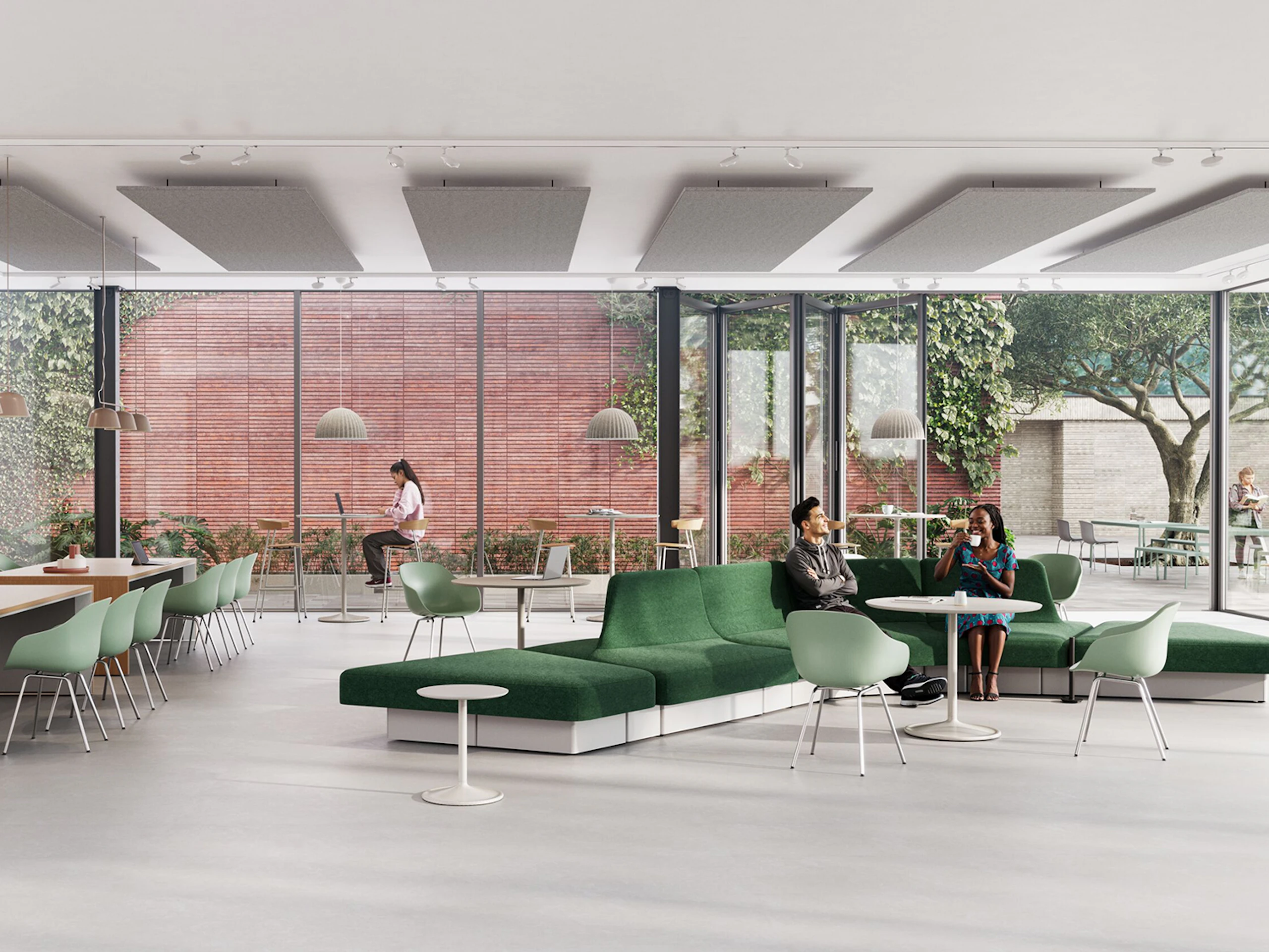 Modern lounge area with green modular sofa, light wood tables, and various seating options. Large windows overlook a green space with trees.