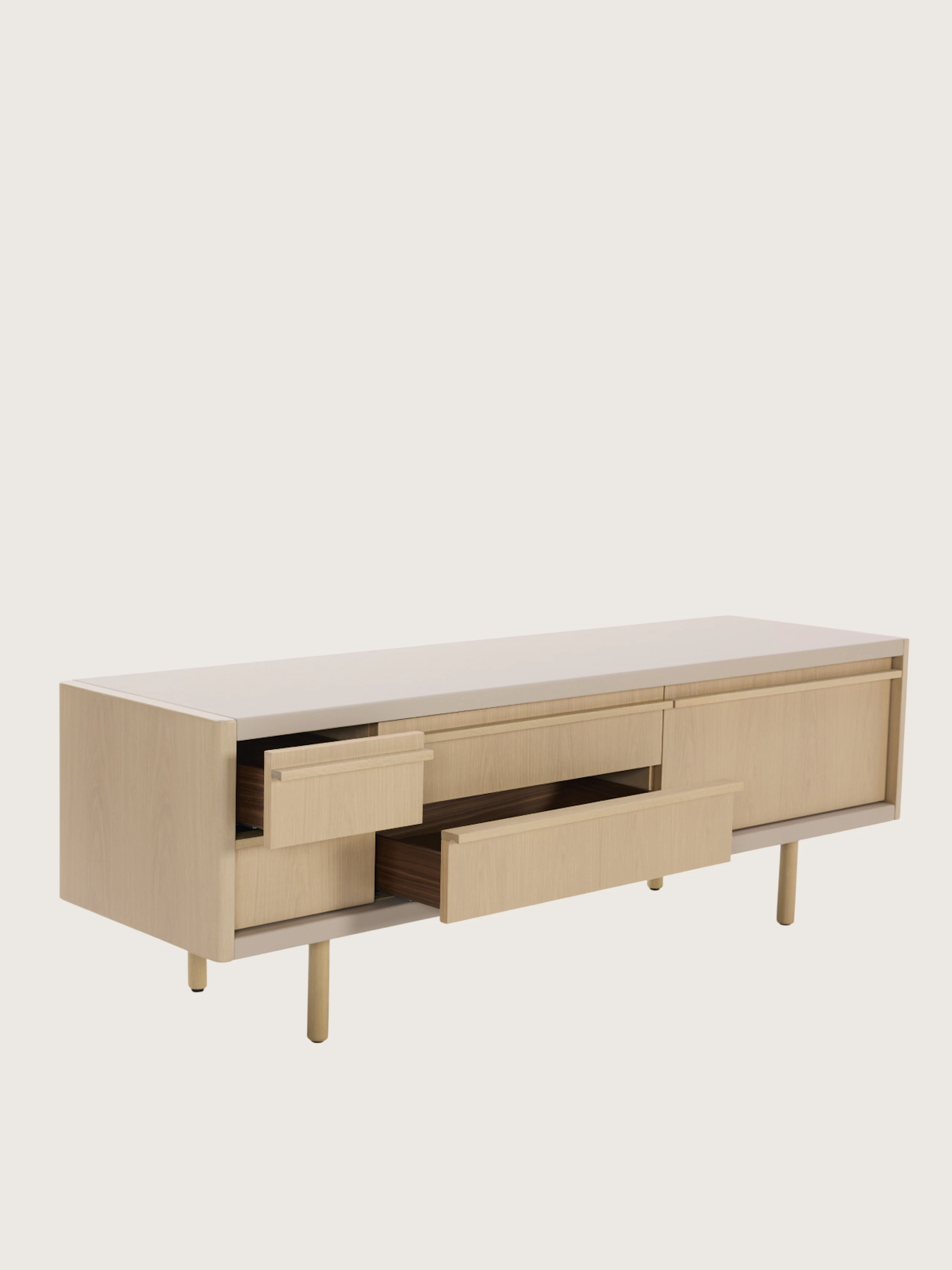New Canaan Media Unit in Oak and Bristol Leather in Champagne with two open drawers, viewed at an angle on a white sweep.