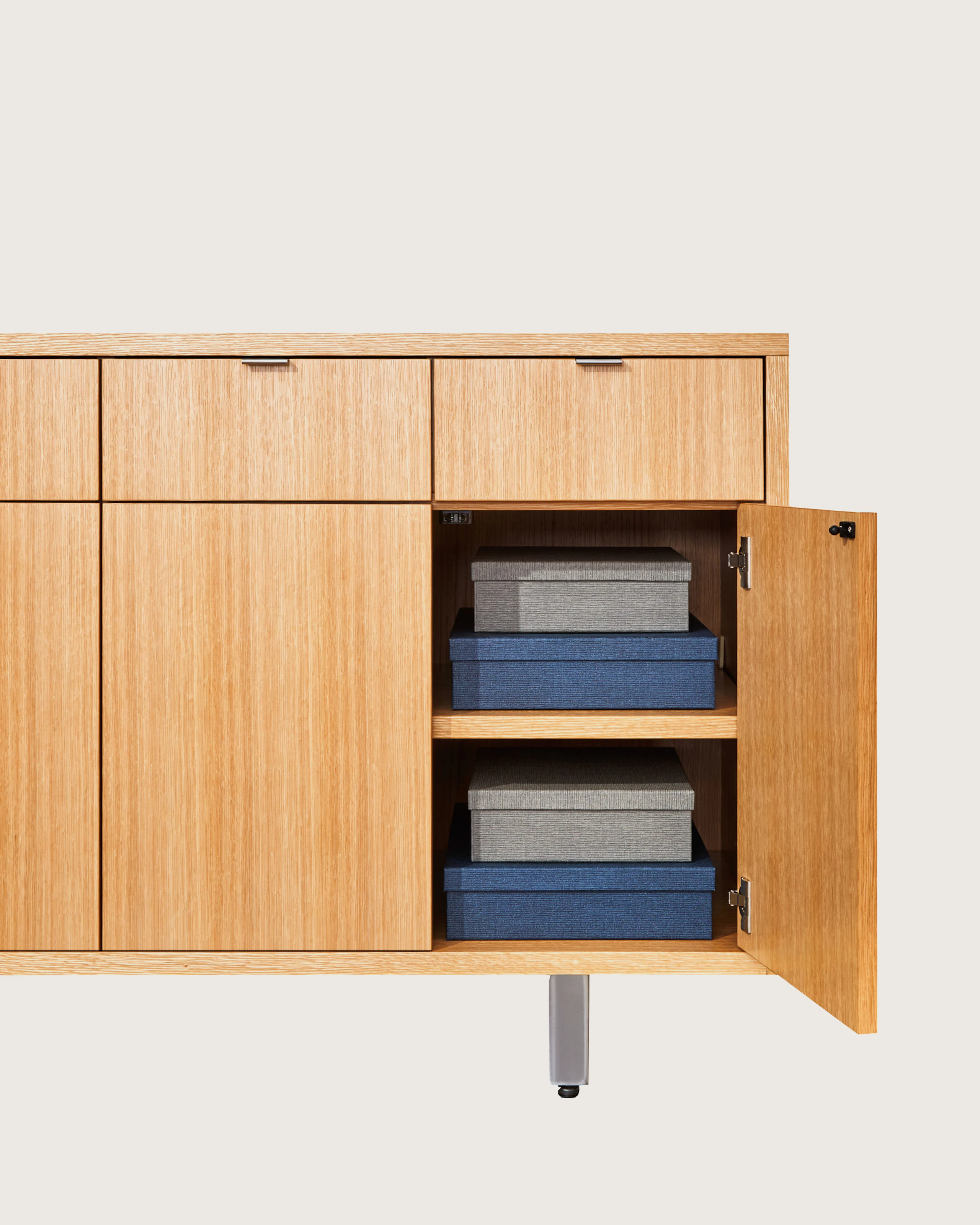 Highline 25 Credenza in Rift Cut European White Oak, open cabinet detail with boxes, front view.