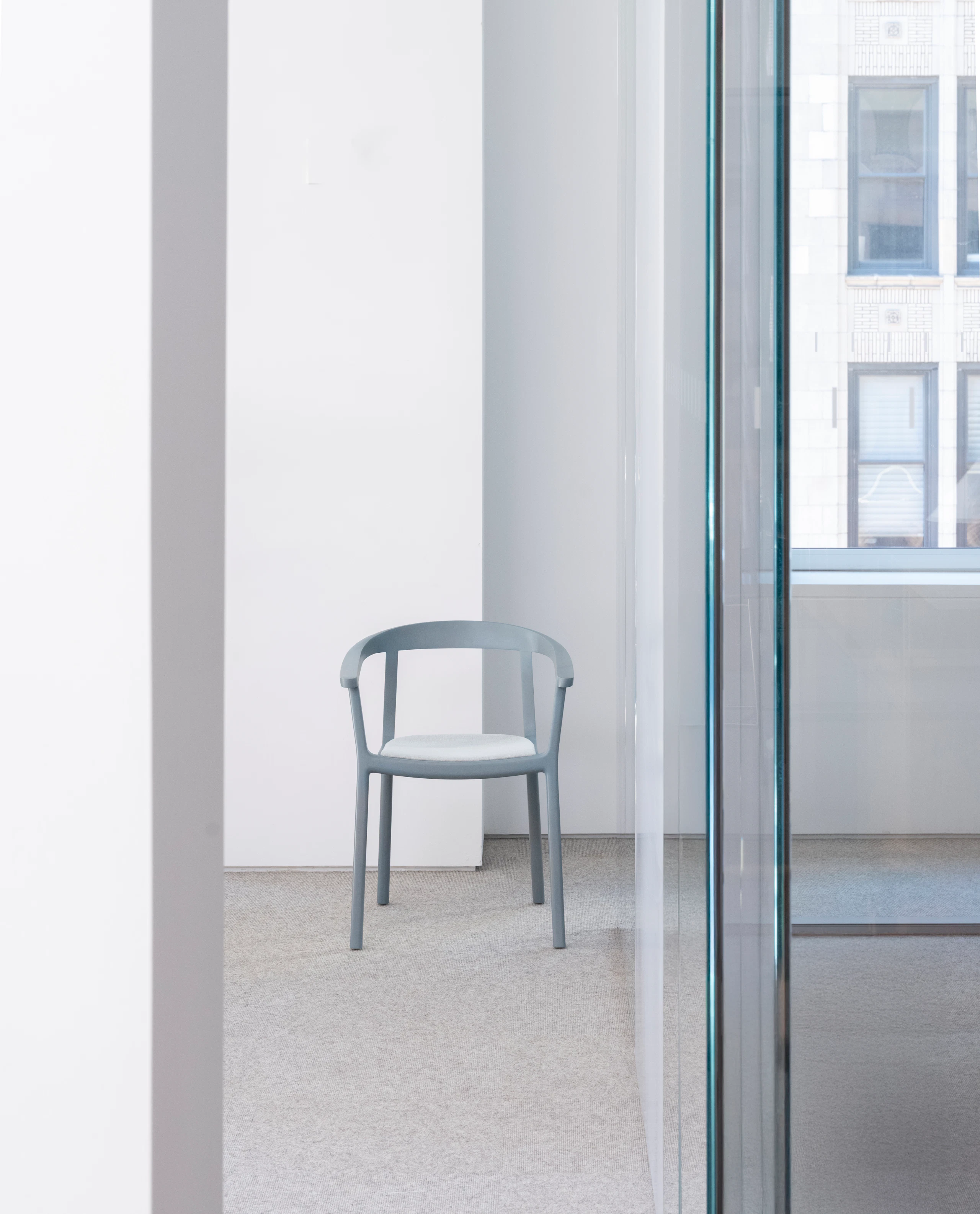Lijn Armchair designed by Carole Baijings in Nordic Blue with the seat upholstered with Luce in Brine, viewed from the front in an office setting.