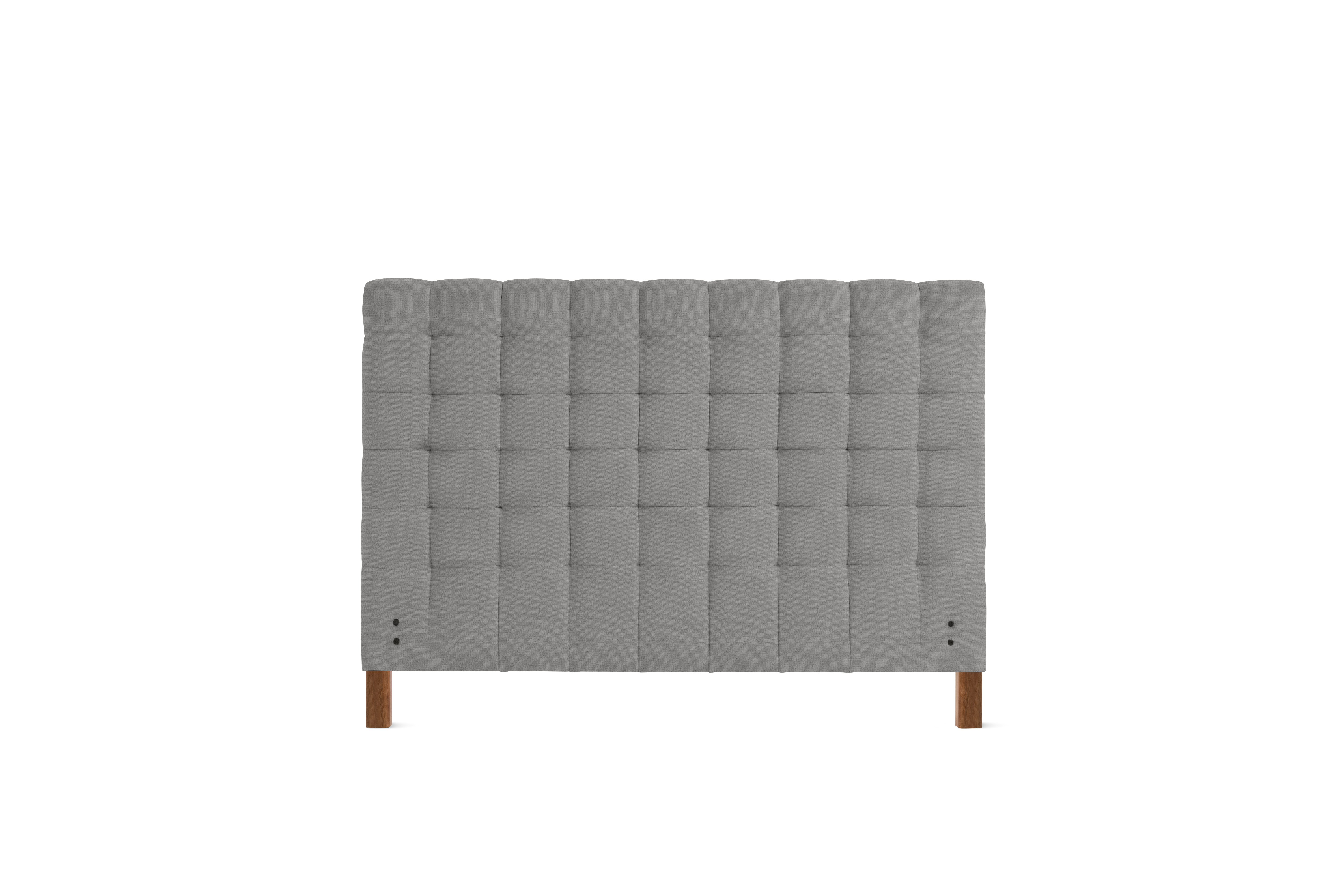 A Madeleine Headboard in Beck, Plutonic, Walnut viewed from the front.