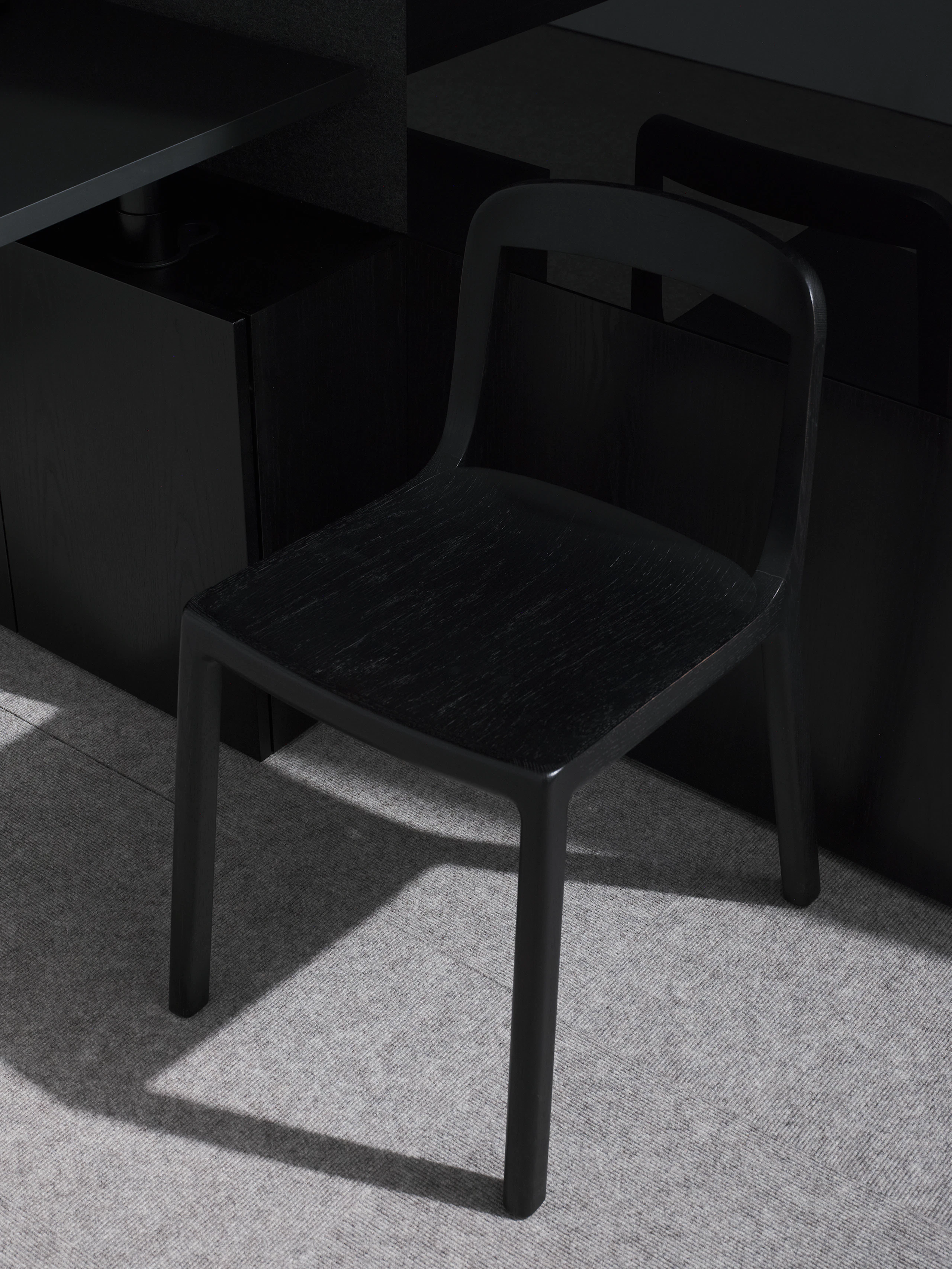 Lijn Side Chair in Ebonized Oak with an open back and wood seat in a private office setting, viewed from above at an angle.
