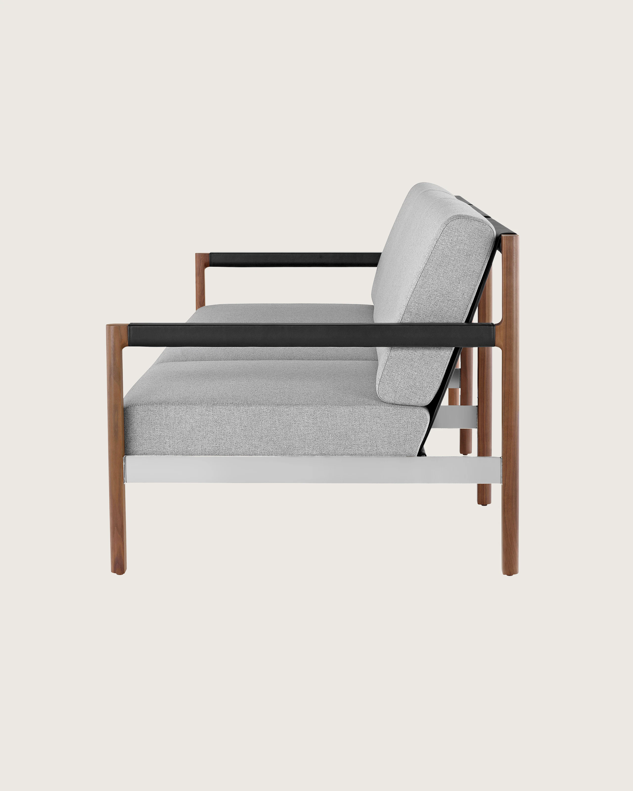 A Brabo Sofa with light gray upholstery, leather and metal accents, and an exposed wood frame. Viewed from the side.