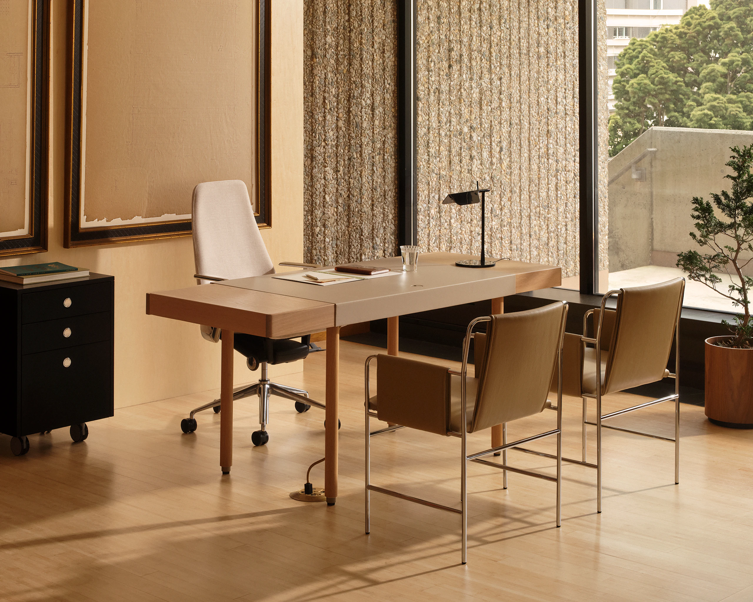 New Canaan Leatherwrap Desk, Tape Chair, two Envelope Chairs for guests, and a Sled Base Storage Pedestal, viewed at an angle in an office setting.