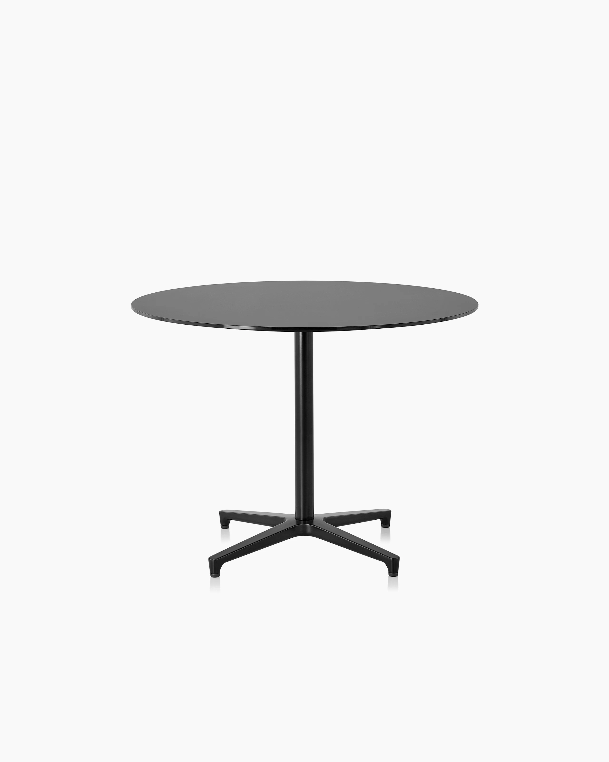 A round Saiba occasional table with a black laminate top and black base.