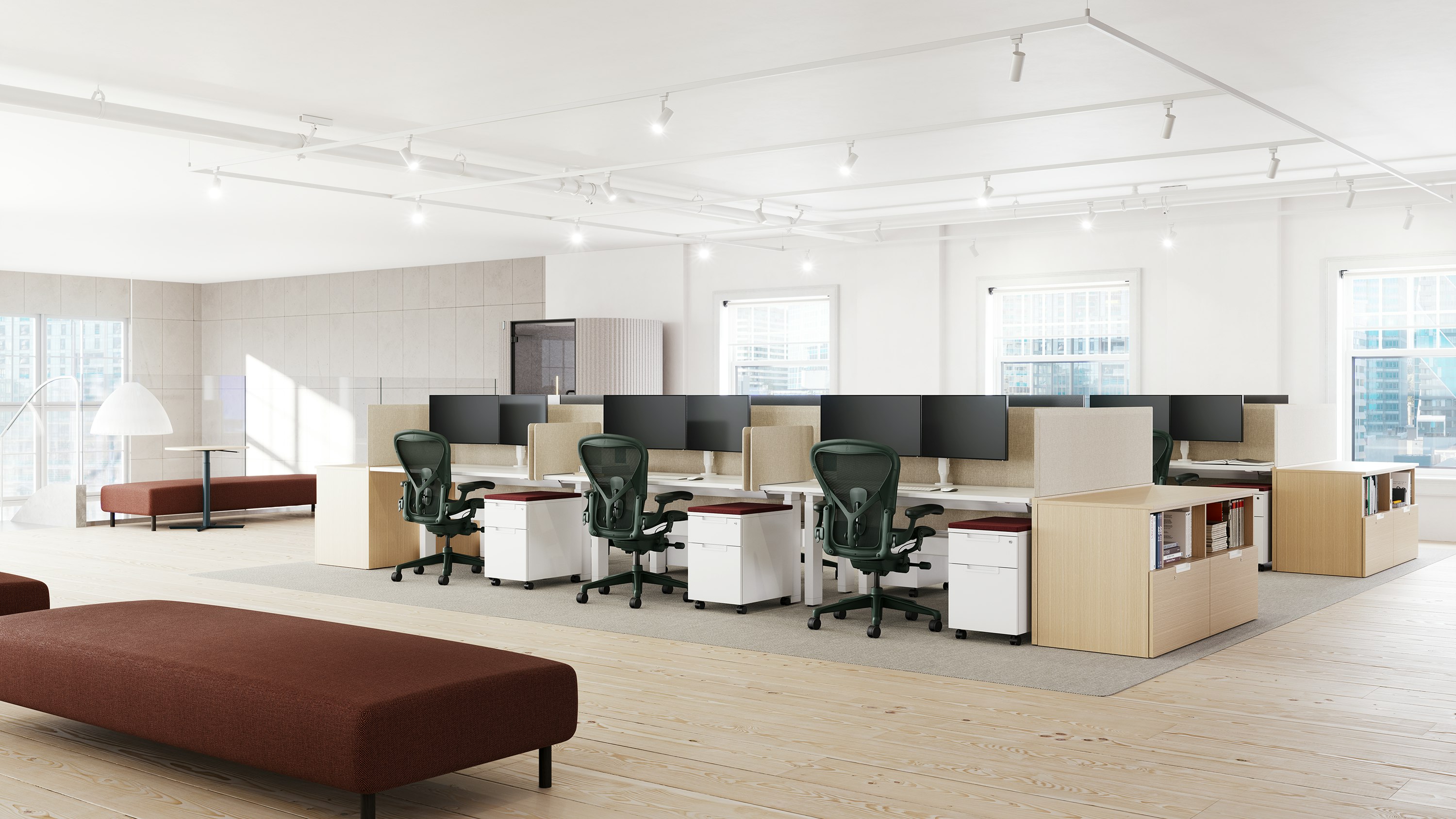 Two sets of workstations, each with six Aeron chairs in dark green.