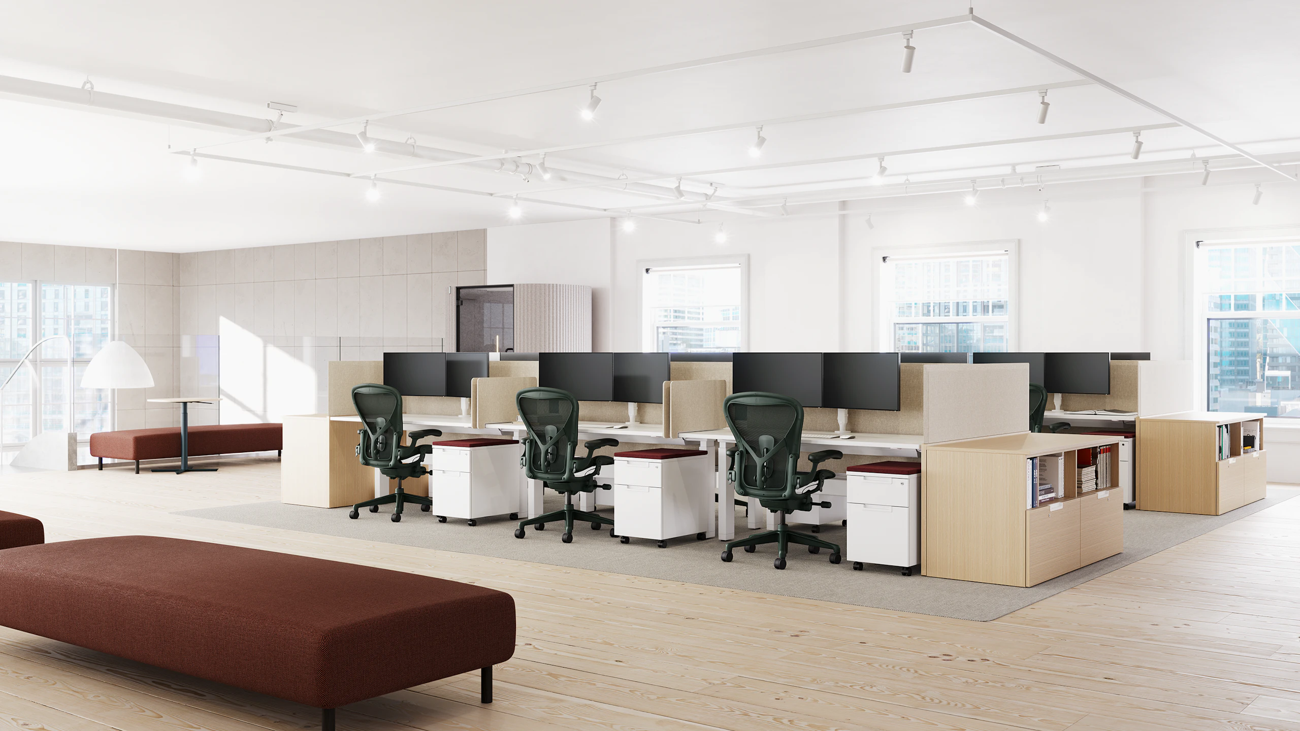 Two sets of workstations, each with six Aeron chairs in dark green.