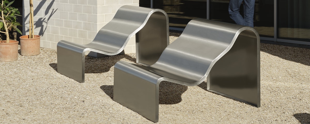 Two Dream View Benches in an outdoor stone gravel courtyard