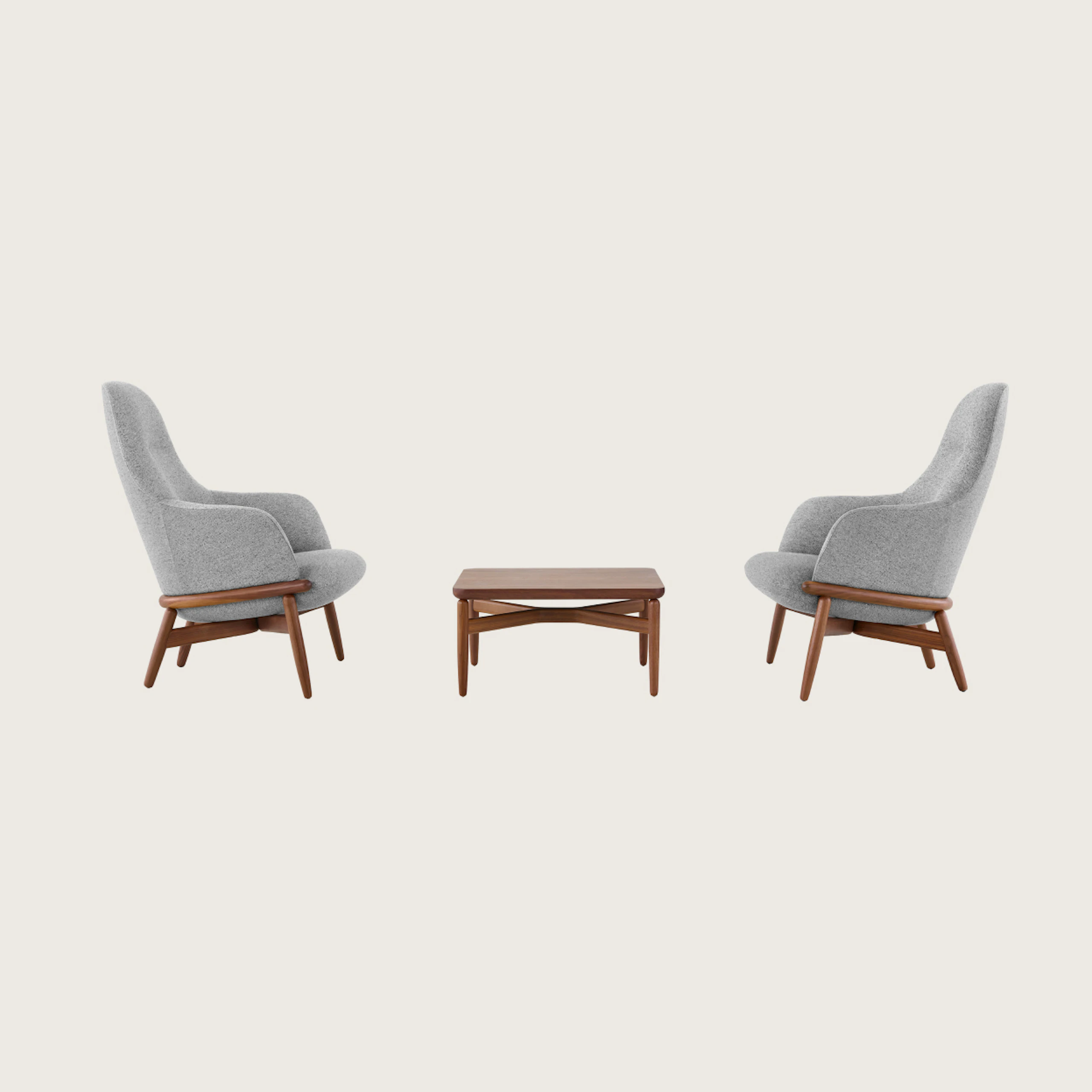 Two gray upholstered Reframe High-Back Lounge Chairs on either side of a walnut Reframe Table.
