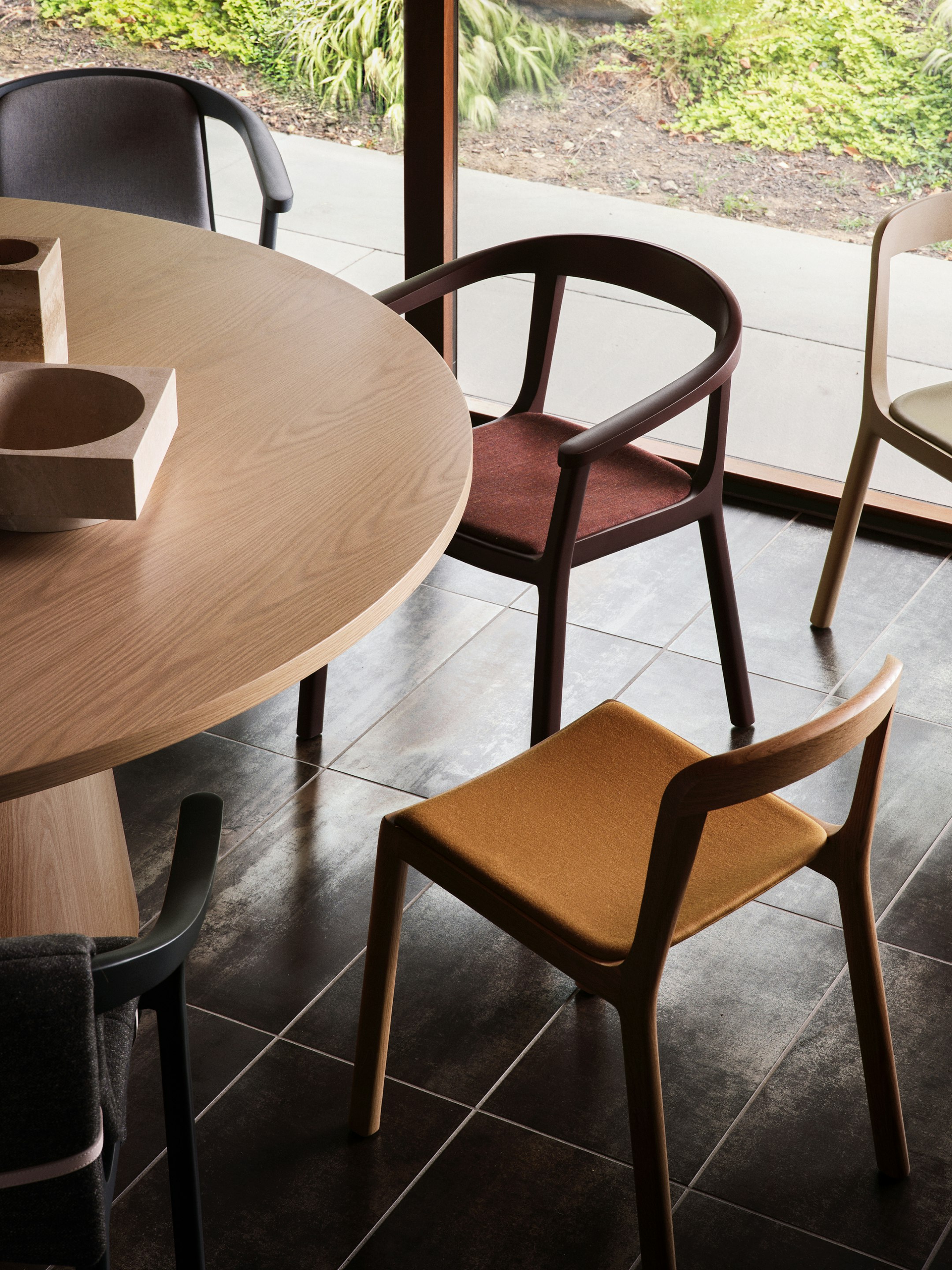 Lijn Armchairs and Side Chairs designed by Carole Baijings for Geiger in a variety of wood stains; textiles; and leather upholsteries shown surrounding a JD Meeting Table.